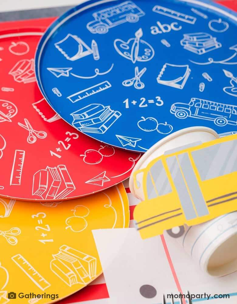A close up of a back to school party featuring school themed party supplies from Momo Party including school day assorted side plates with school supply patterns in 4 colors of green, blue, red and yellow, with the No. 2 pencil patterned dinner plates and loose leaf paper placemats by Gatherings. A perfect place setting to celebration kid's or student's first day of schoo,