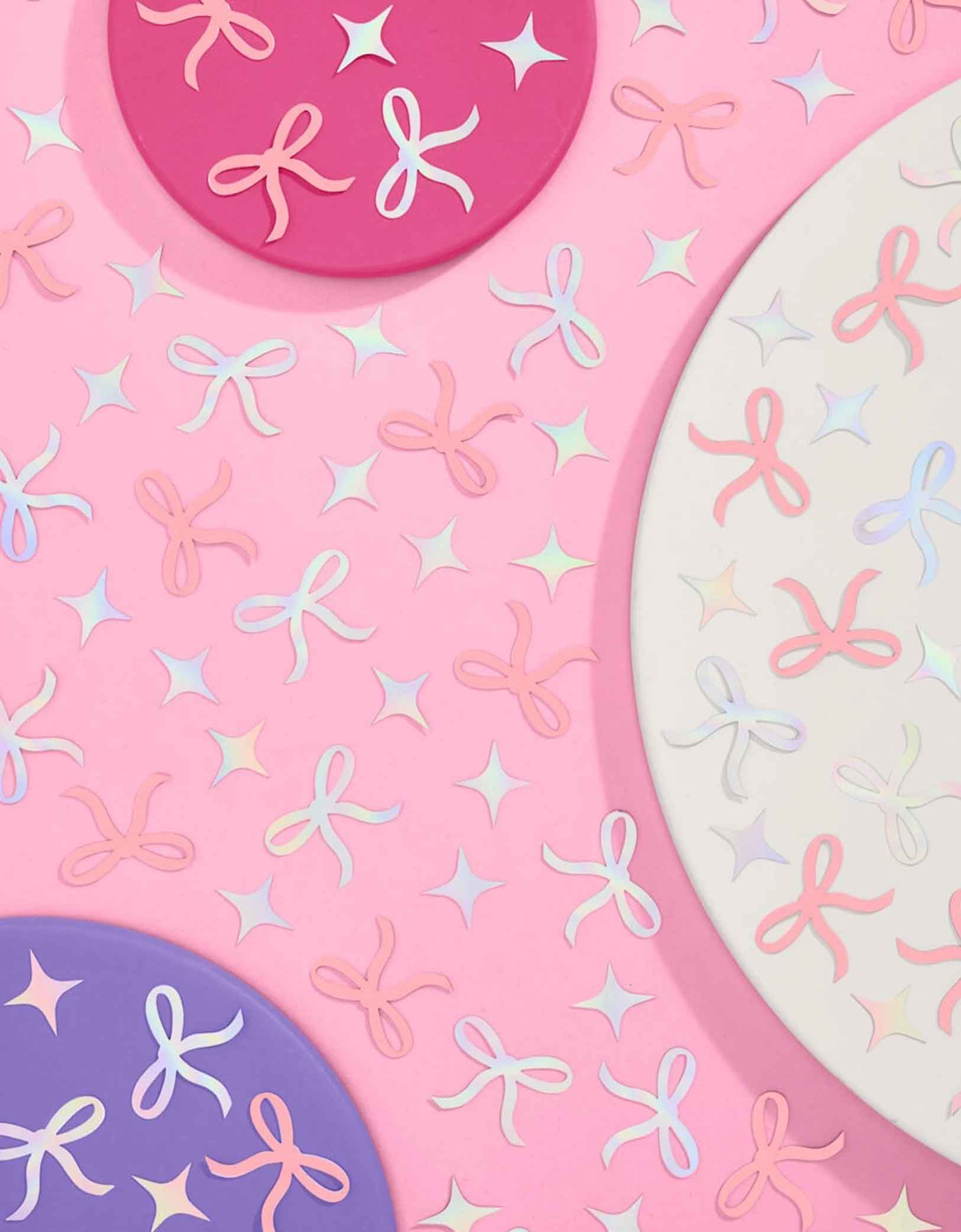 Momo Party's bow shaped confetti and star point shaped confetti in pink and iridescent on a pink background.