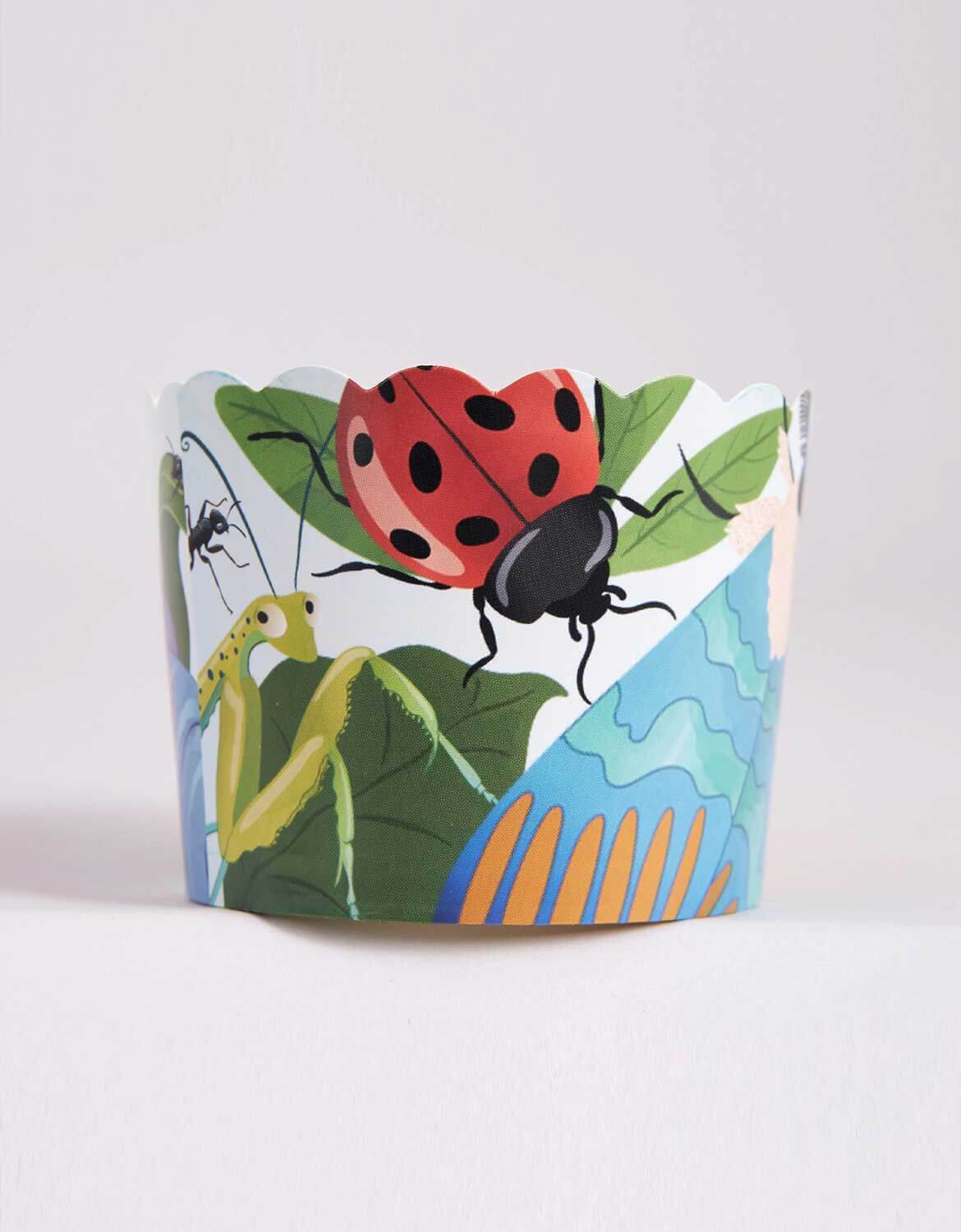 A colorful baking cup with insect illustrations on a white background.