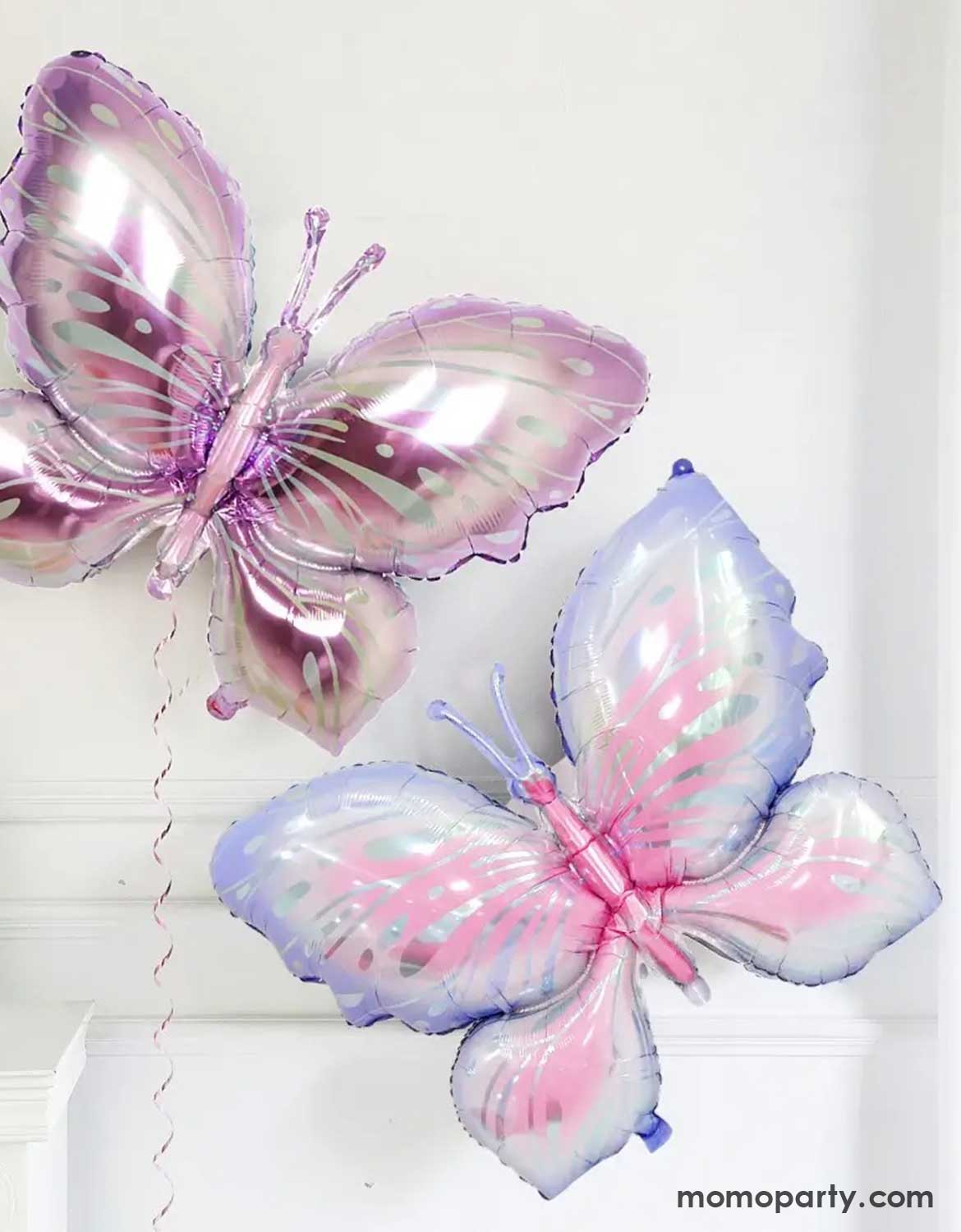 Two butterfly-shaped foil balloons with iridescent foil from Momo Party on a white background,