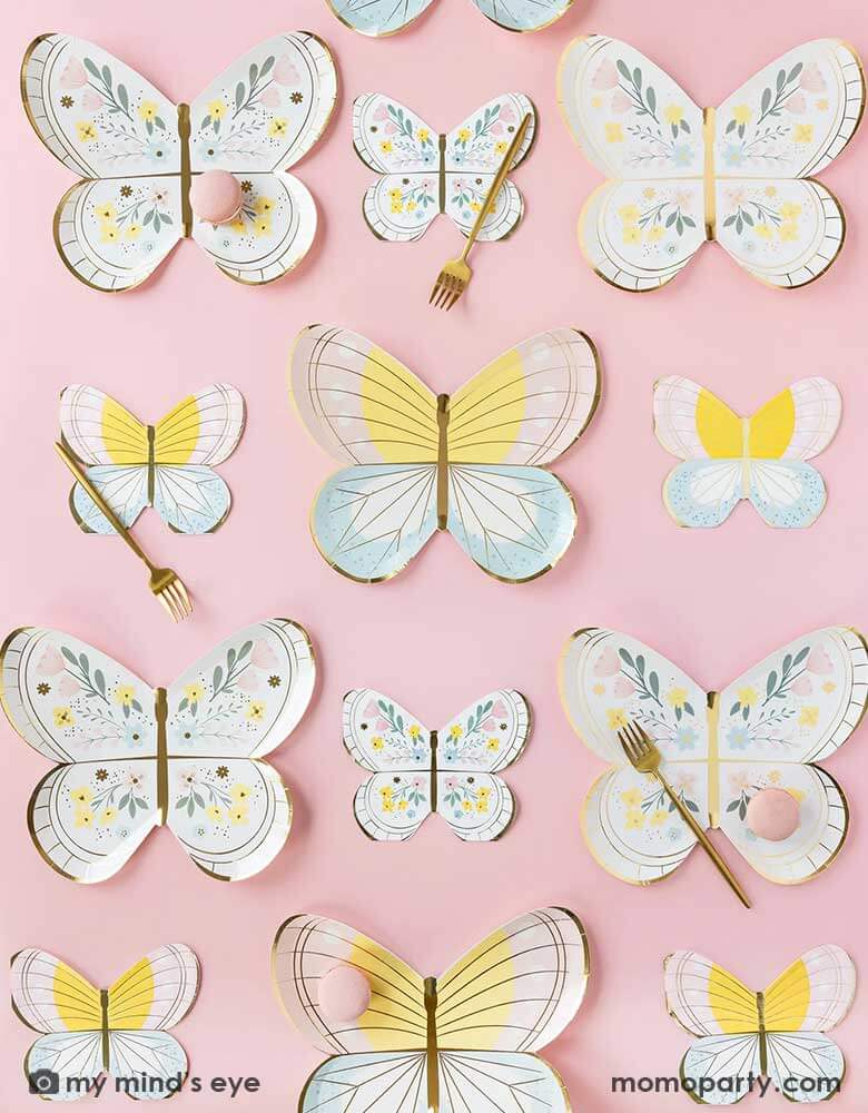 Momo Party's 10" butterfly shaped plates and napkins by My Mind's Eye lined up on a pastel pink table. With gold forks and pink macarons, this makes a perfect inspo for a spring gathering. 