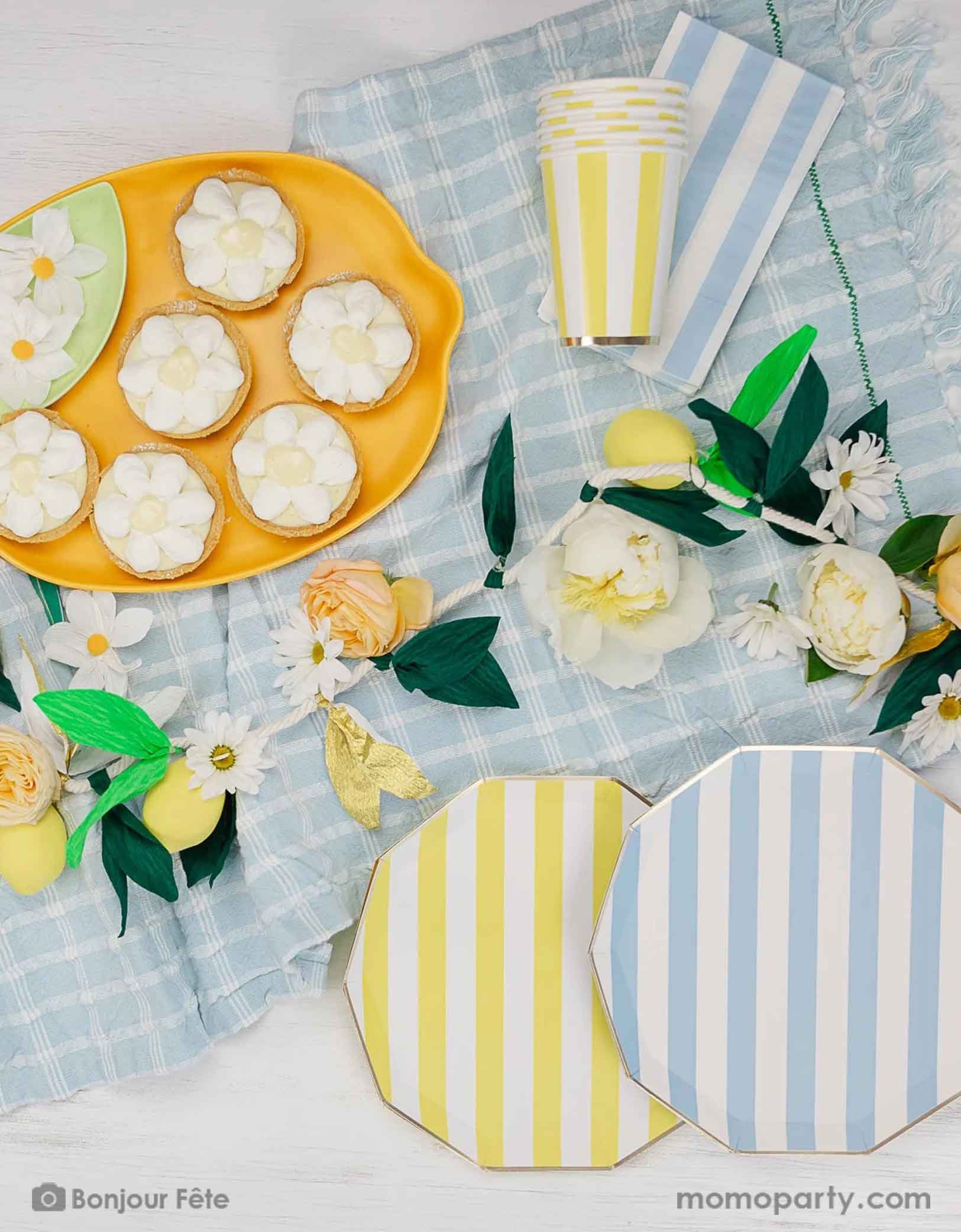 A stunning tableset in a Summer Party Capri Inspired party by Momo Party! Bursting with colors and textures, this stylish setting combines the vibrant striped aesthetics in yellow and sky blue of Capri with the refreshing citrus vibes of lemons and gingham checker patterns. Your guests will be transported to a picturesque seaside Italian village as they enjoy their summer feast underneath these enchanting decorations.