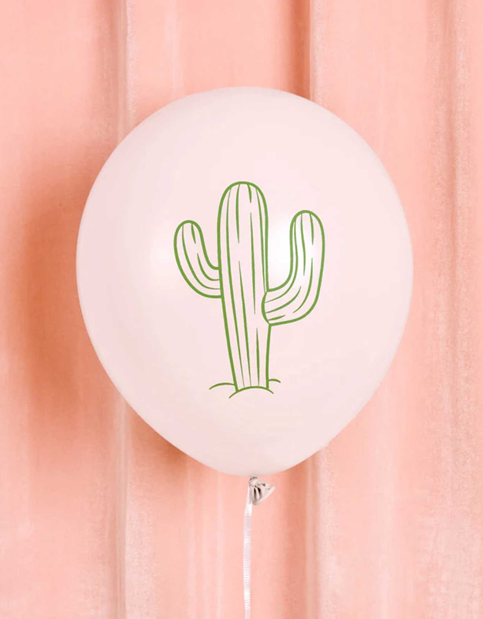 A 12" white latex balloon with green cactus design from Momo Party on a pink curtain background.