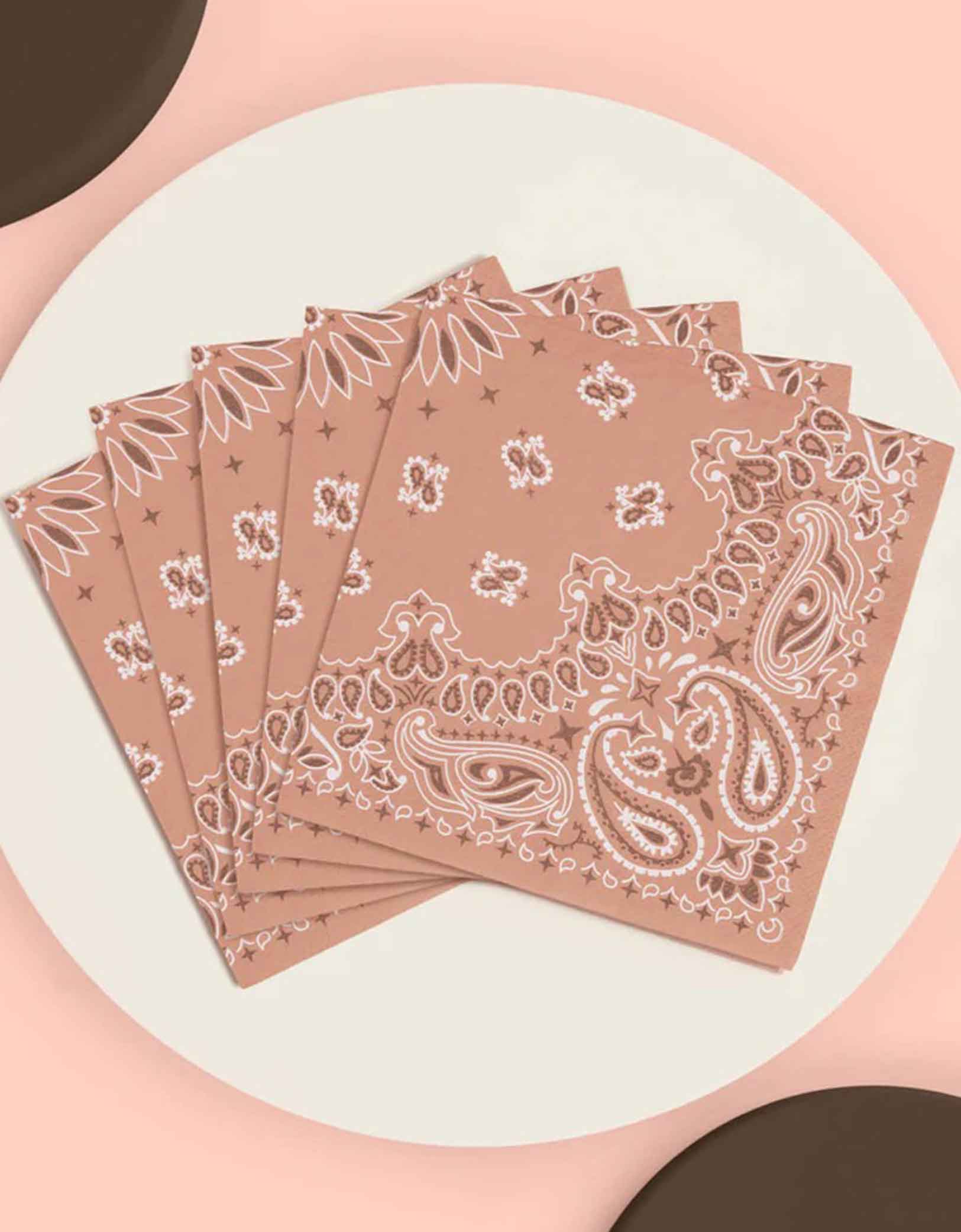 A set of 5" x 5" Western cowboy rodeo themed small napkins with bandana design from Momo Party on a pink an brown background.