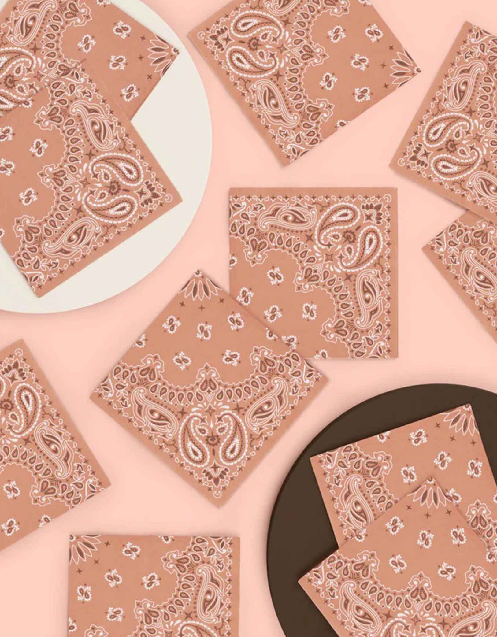 A set of 5" x 5" Western cowboy rodeo themed small napkins with bandana design from Momo Party spread across on a pink and brown background.