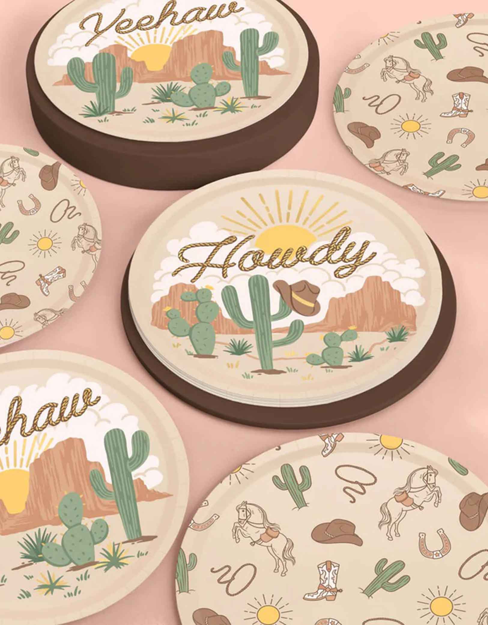 A set of cowboy-themed party plates with desert-themed designs featuring cacti, cowboy hats, and text on a pink background.