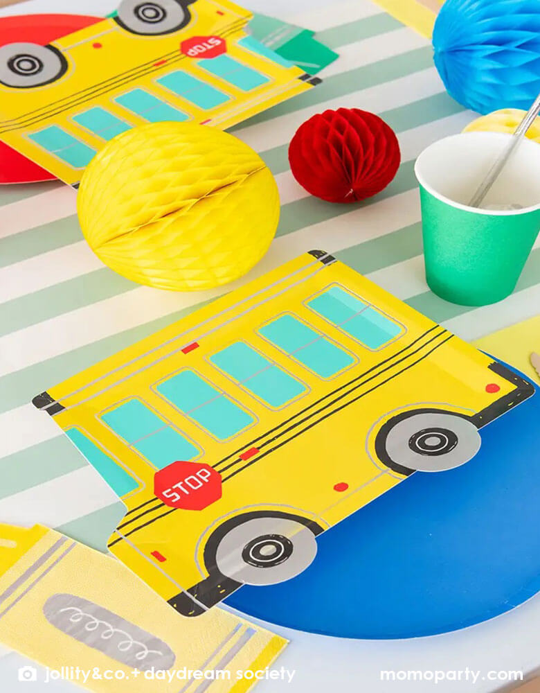 A festive back to school party featuring Momo Party's colorful school themed tableware including Daydream Society's school bus shaped plates, crayon shaped napkins with bright colored round plates and party cups. With festive colored honeycomb decorations on the party table, this gives a great idea and inspiration for a kid's back to school celebration.