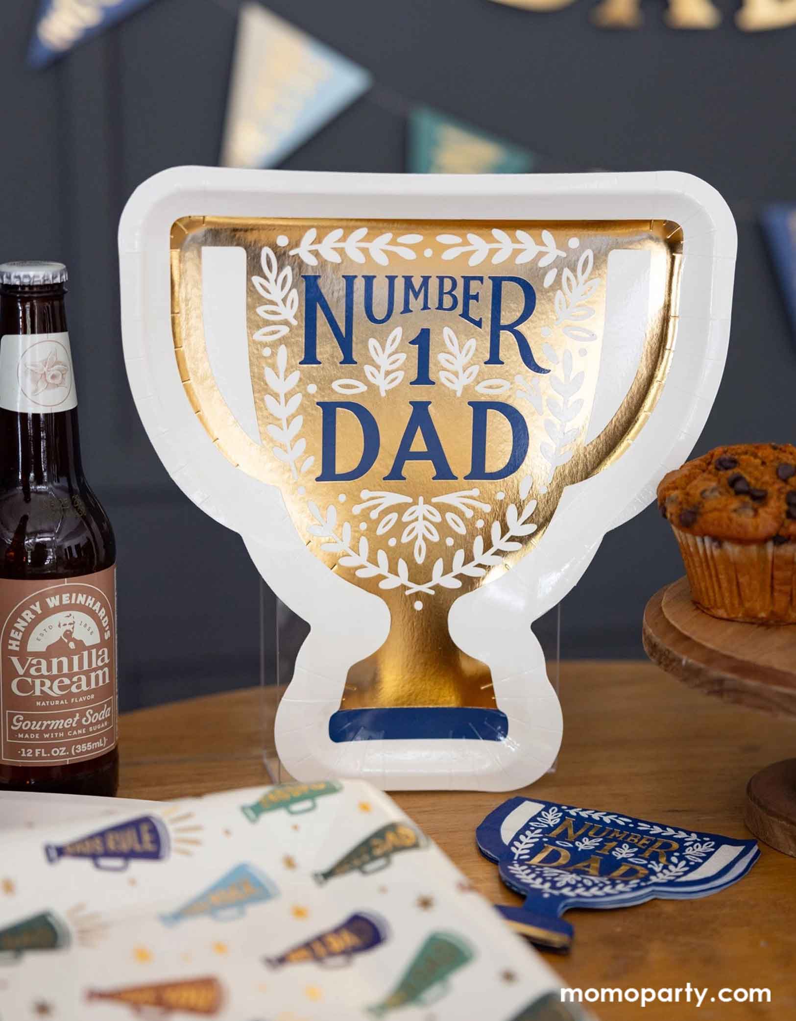 A Father's Day celebration party table featuring Momo Party's Father's Day party supplies including the 10" x 10.5" Number 1 Dad Trophy Plates & matching napkins, and megaphone patterned dinner plates, some beers & muffins. Behind the table there's a Happy Father's Day banner with pennants hung on the navy wall, making this a perfect scene for a fun and playful Father's Day celebration!
Perfect for a Father's Day celebration,