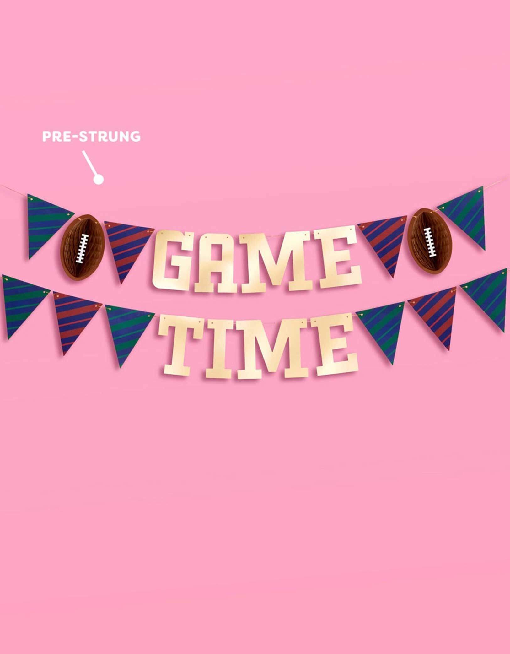 Momo Party's pre-strung 4.5' football gold foil game time banner on a pink background.