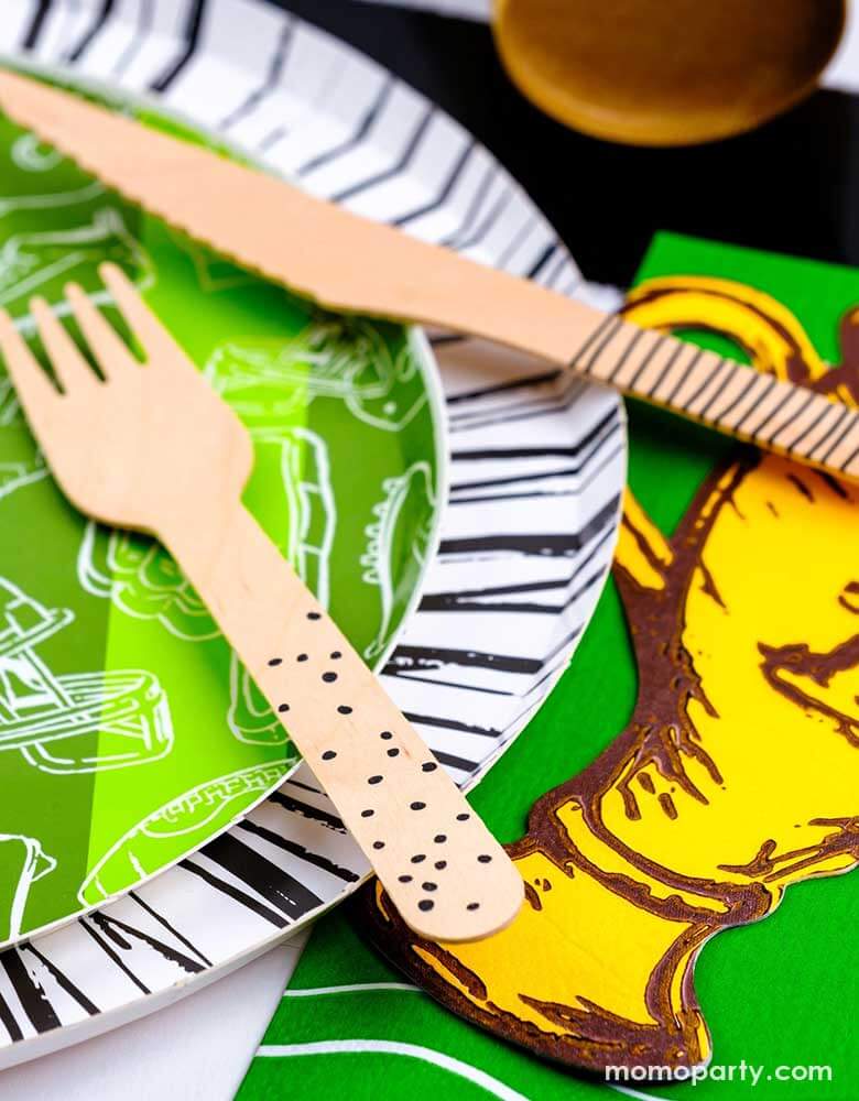 A closer look of a modern yet festive football party tablescape featuring football themed tableware from Momo Party including the football shaped paper placemat, the touchdown dessert plates, the trophy shaped napkins on a black striped table runner, making this a perfect inpo for a kid's football themed birthday party or a Superbowl party table decoration.