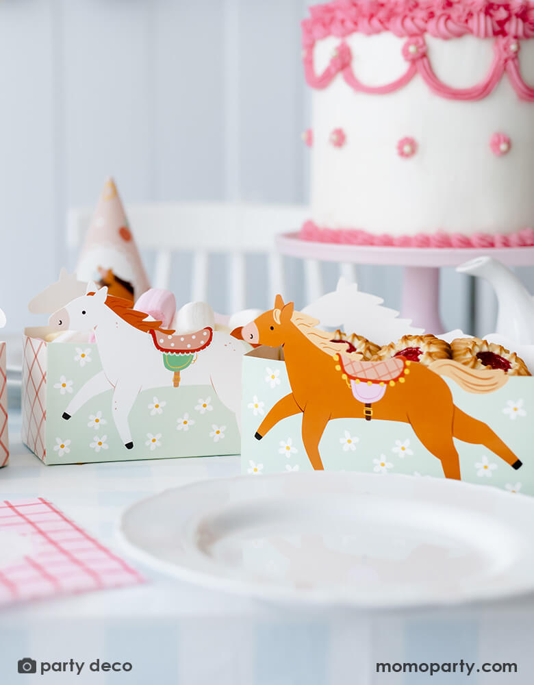 A horse/pony themed birthday party table features Momo Party's 6.7" x 4.3" x 2.95" floral pony treat boxes by Party Deco. Each snack box has some delicious treats in them including cookies and macarons. Behind the treat boxes are some party hats and a pink and white buttercream cake in vintage piping design - making this a darling inspo for girl's pony themed party.