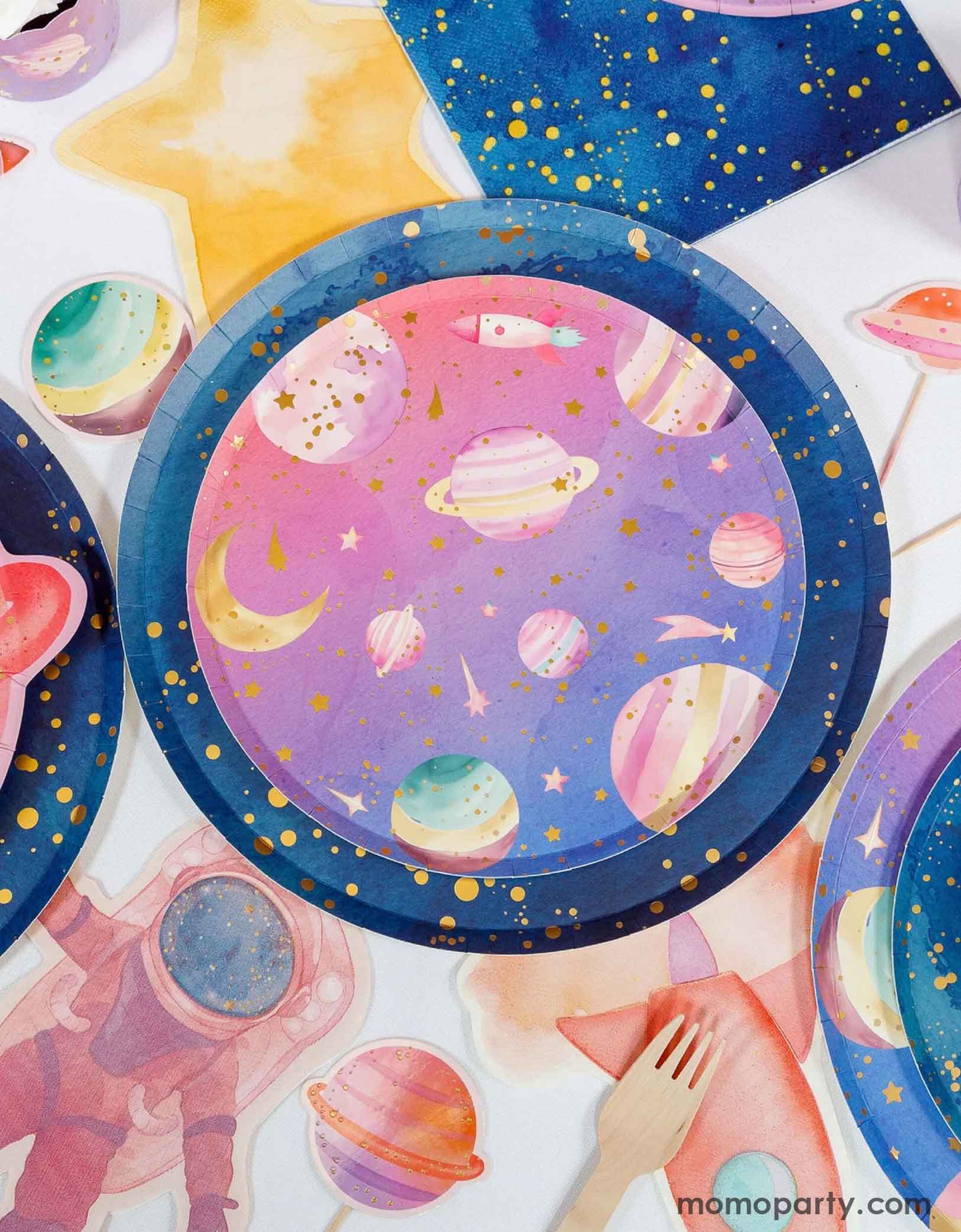 Momo Party's colorful pink space-themed paper plate with pink astronaut napkins, galaxy napkins and some space themed cupcake toppers, along with a pink planet shaped plate on a white background.