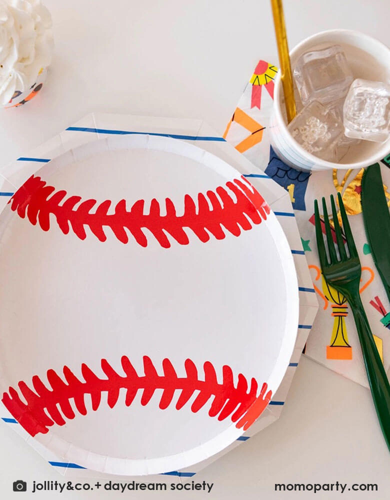 A sports themed party tablescape featuring Momo Party's 7.5 inch baseball plate layered on top of blue striped plates by Daydream Society. On the site there's 6-inch Good Sports large party napkins featuring sports themed illustration including trophies, number 1 fingers, metals, for a fun sports champion celebration!