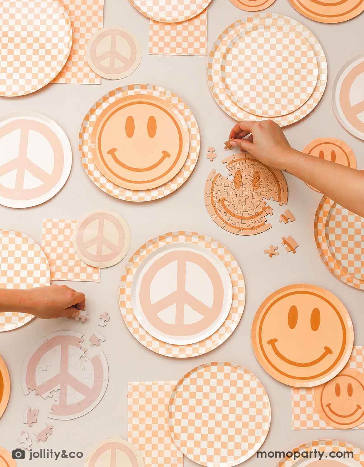 Decorative paper plates with peace signs, smiley faces, and checkered patterns from Momo Party on a light background.