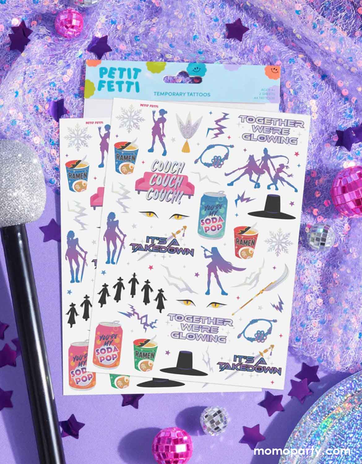 Momo Party's Kpop Demon Hunters themed temporary tattoos sheets of two with colorful graphics including dancing figures, soda pop cans, lightning power symbols and texts by Xo, Fetti on a purple glittery background with pink disco balls decorations, a glittered microphone, and purple foil star shaped confetti elements.