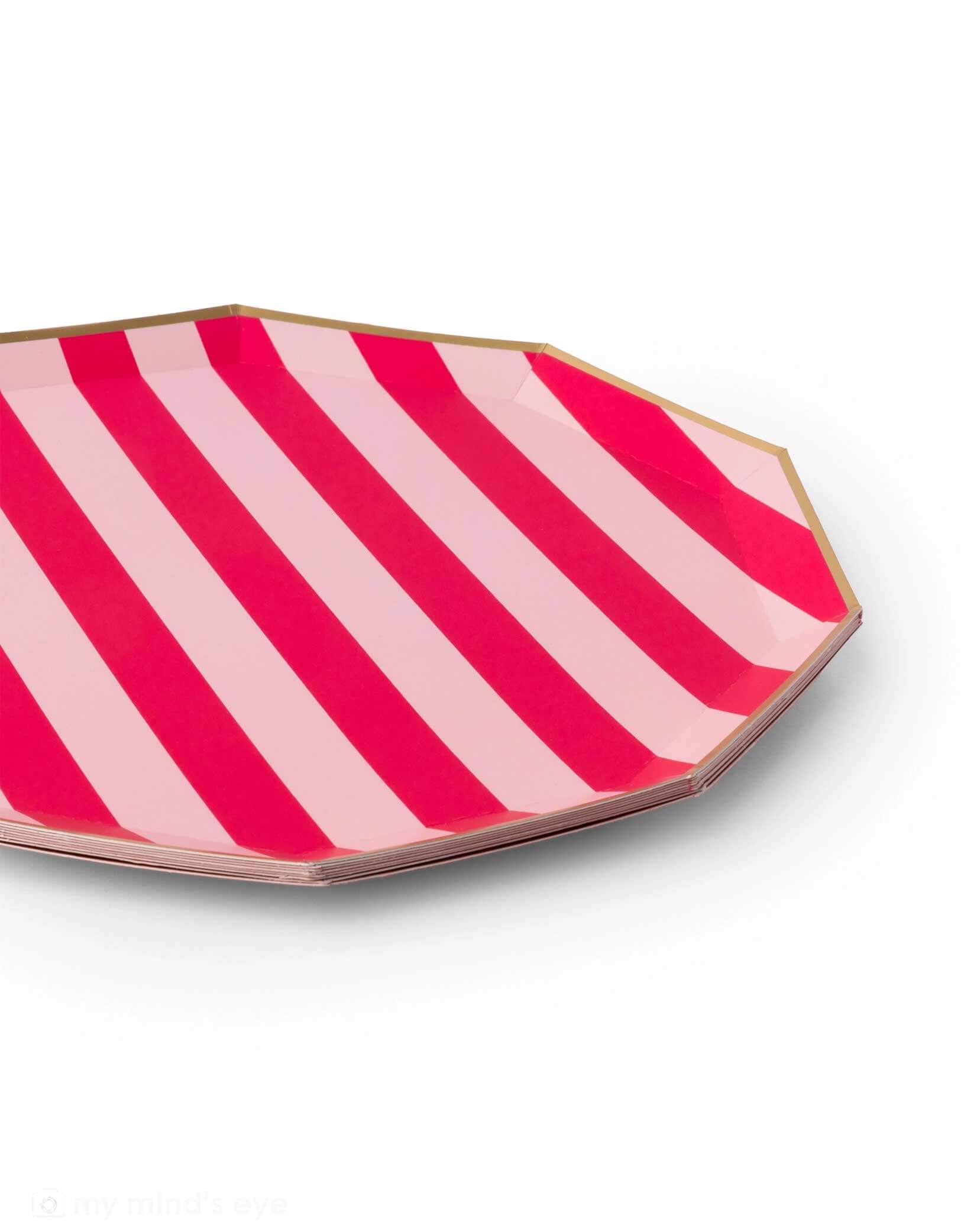 A profile shot of Momo Party's 10.75" octagonal shaped plate with haute pink and light pink vertical stripes by Bonjour Fete on a white background.