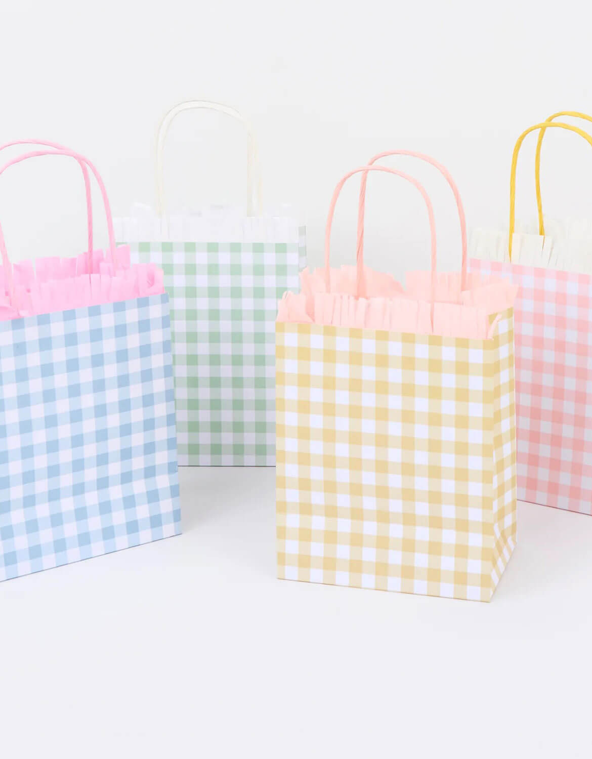 Four colorful gingham party bags on a white background