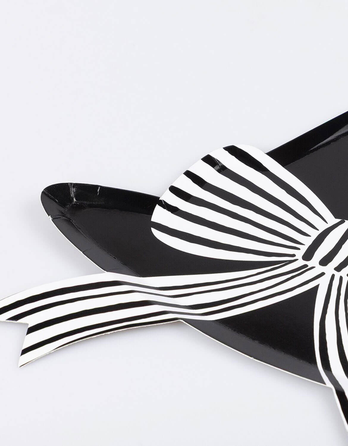 A close-up shot of Momo Party's witch hat shaped plate in glossy black with black and white striped bow design, photographed on a clean white background.