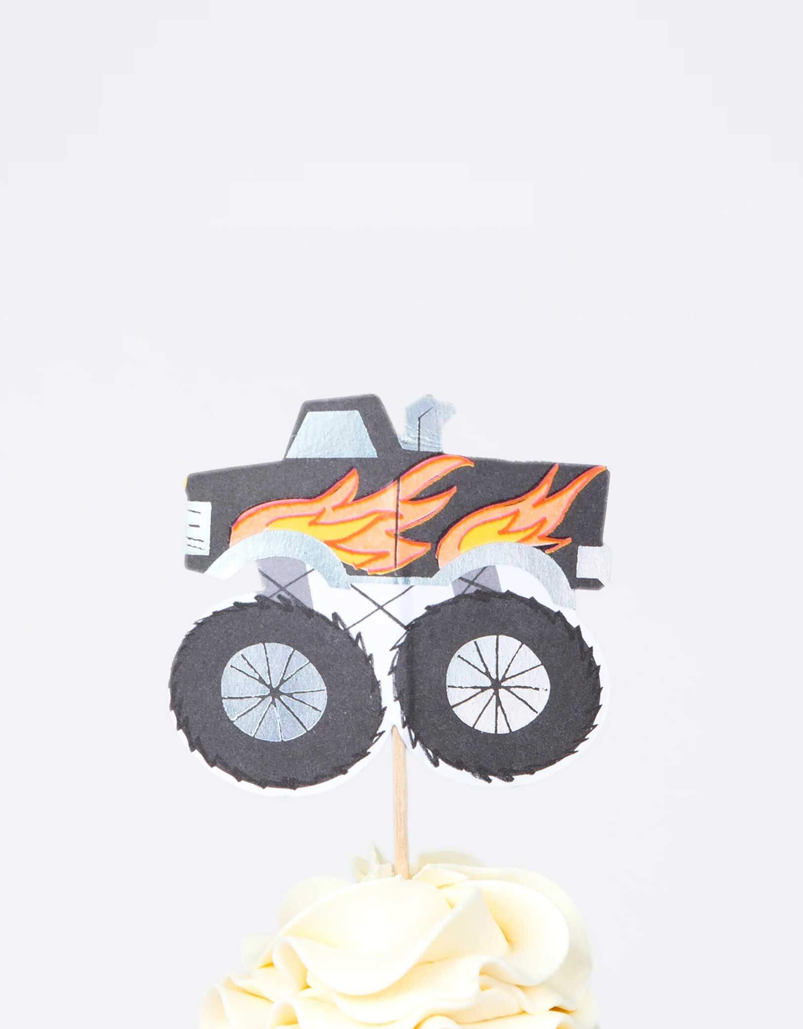 A cupcake decorated with Momo Party's Monster Truck cupcake topper by Meri Meri in black. This fun kit also makes a great gift for kids who love to bake.