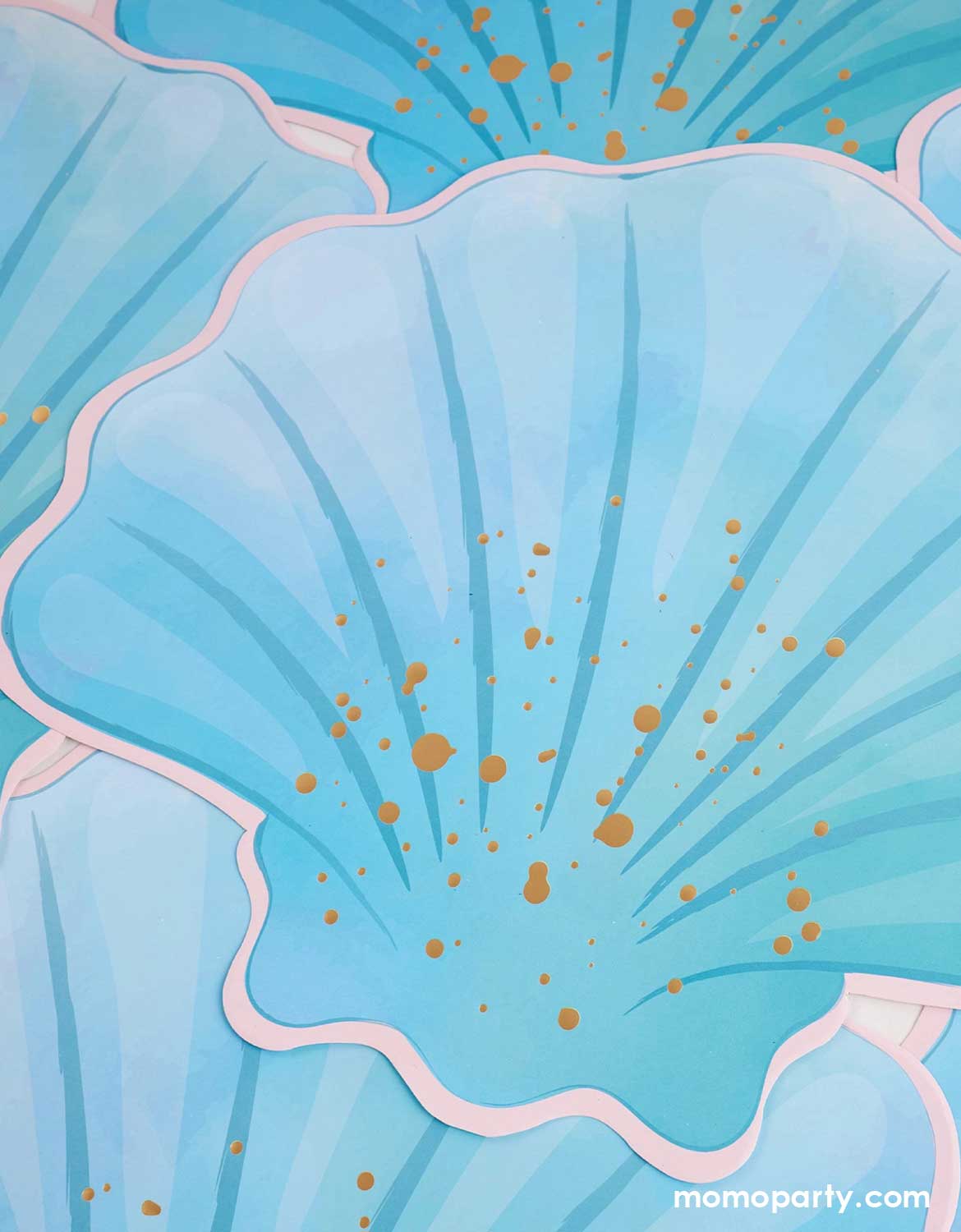 Blue scallop shell with gold dots on a matching blue background.