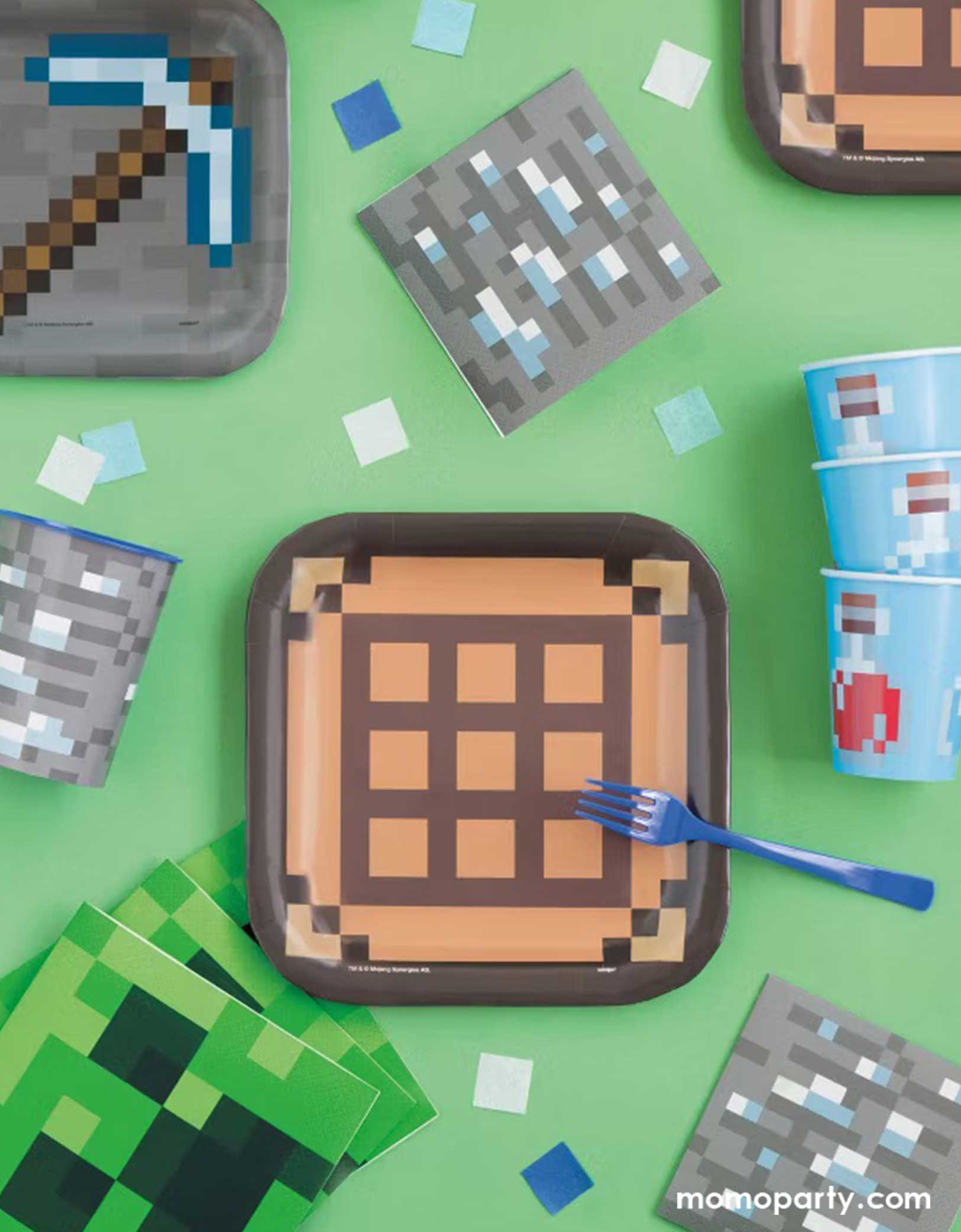 A green kid's Minecraft themed birthday party table featuring Momo Party's Minecraft themed party tableware including 8" brown and black brick paper plates, the 7" pickaxe paper dessert plates, Creeper napkins, gray brick napkins and blue pixelbomb paper cups, making this a fun and great party collection for kid's Minecraft themed birthday celebration!