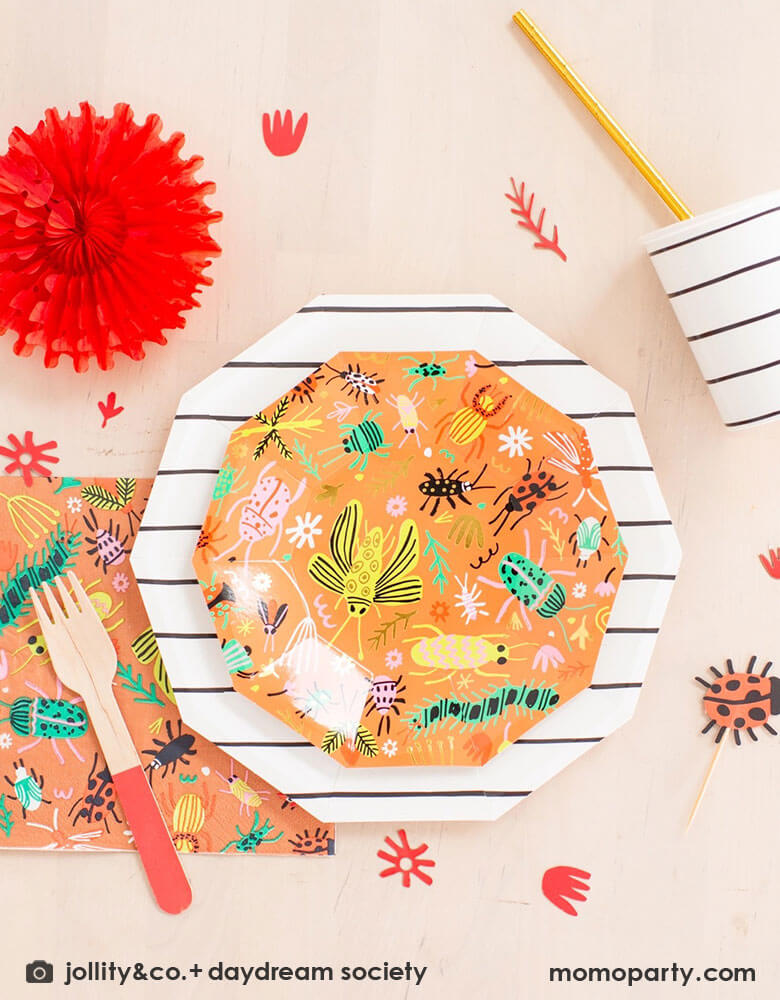 A kid's bug theme birthday party table filled with Momo Party's backyard bug themed party supplies and tableware including plates, napkins and confetti. With neon tone bugs in modern illustrations, these bug themed partyware if perfect for your child's crawling bug inspired party!