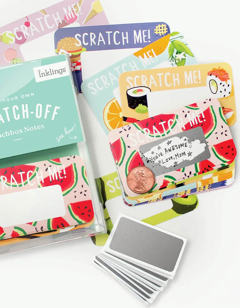 Momo Party's Scratch-off Lunchbox Notes by inklings Paperie. Kit included 24 scratch off cards with food illustrations including watermelon, burgers, sushi, fruits, avocado. Each set includes 24 stickers, in a clear plastic box. Simply write your own special handwritten message in the designated area, cover it with the scratch-off sticker provided, and scratch to reveal your hidden message! These tiny notes are the perfect size to slip into a lunch bag or coat pocket of someone special.