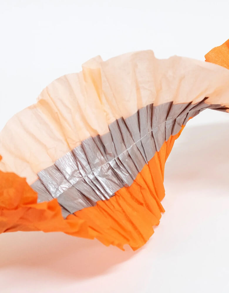 Momo Party's 10' orange, pink and silver stitched streamer by Meri Meri. With a stunning trio of orange, shiny silver and peach, it's a perfect decoration for your sweet pink Halloween celebration!