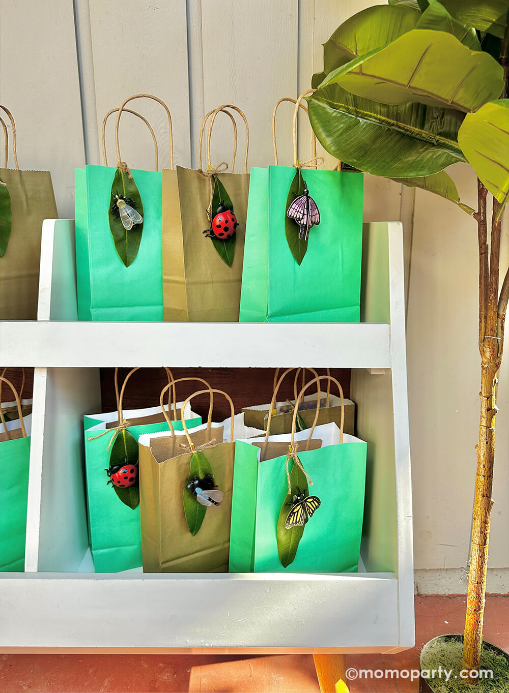 A diy project using Momo Party's various insect finger puppets and real leaves as decoration to party favor bags for kid's bug insect themed birthday party.