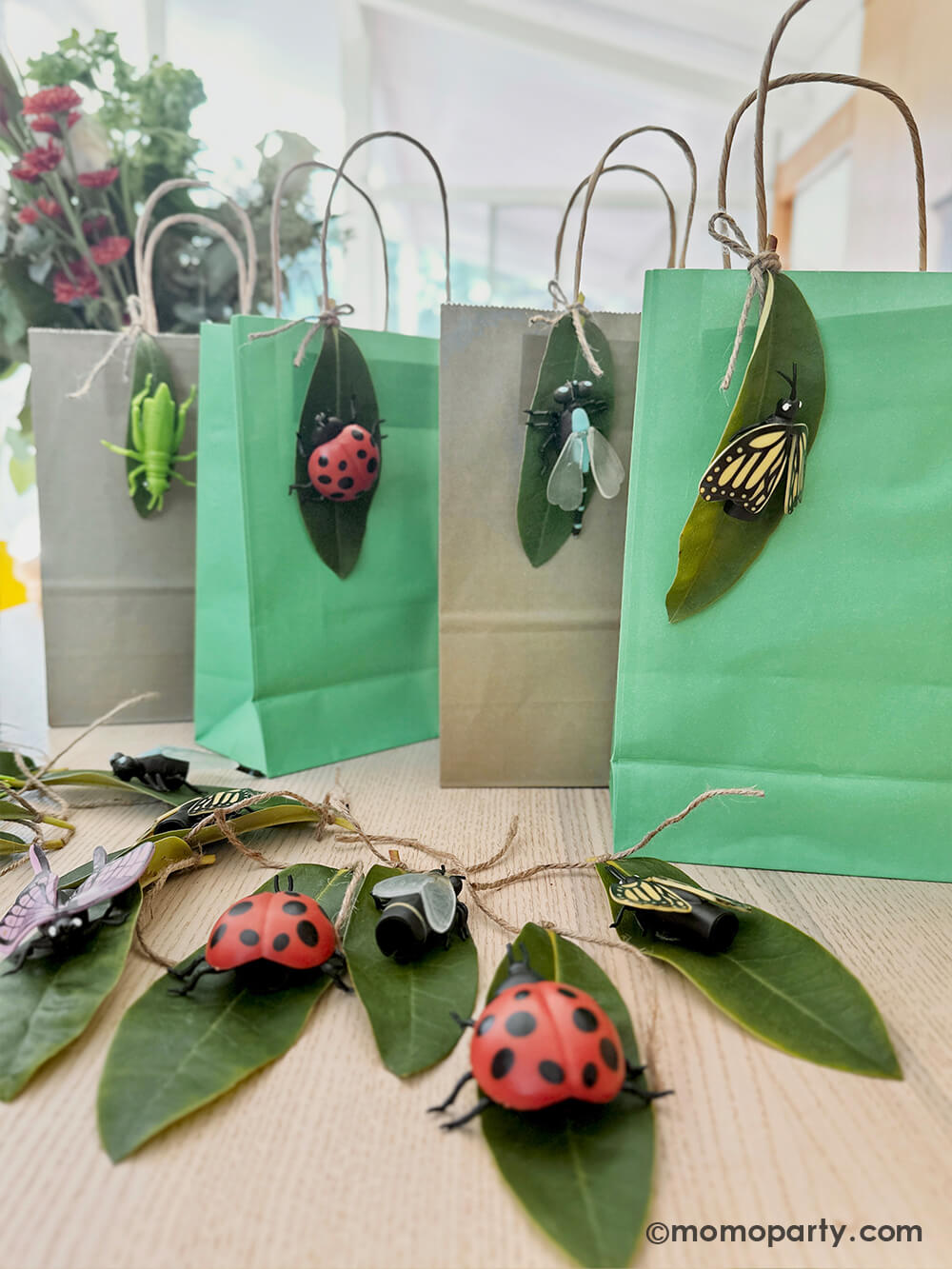A diy project using Momo Party's various insect finger puppets and real leaves as decoration to party favor bags for kid's bug insect themed birthday party.