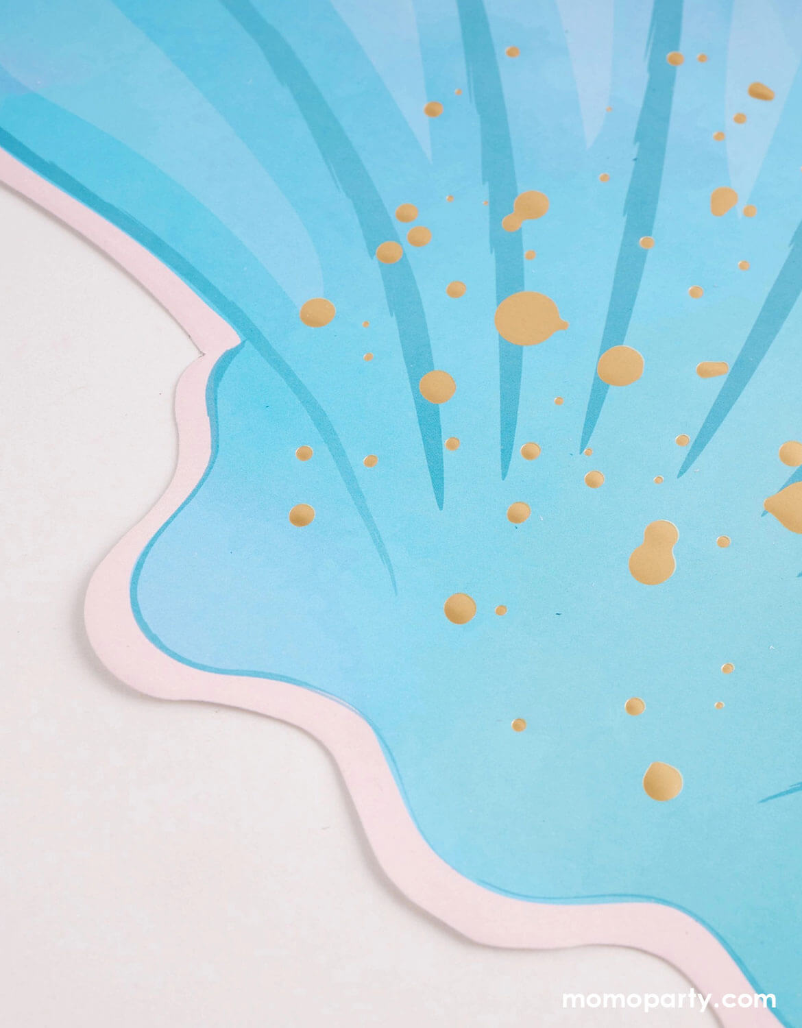 Blue and pink shell-shaped placemat with gold polka dots on a light blue background.