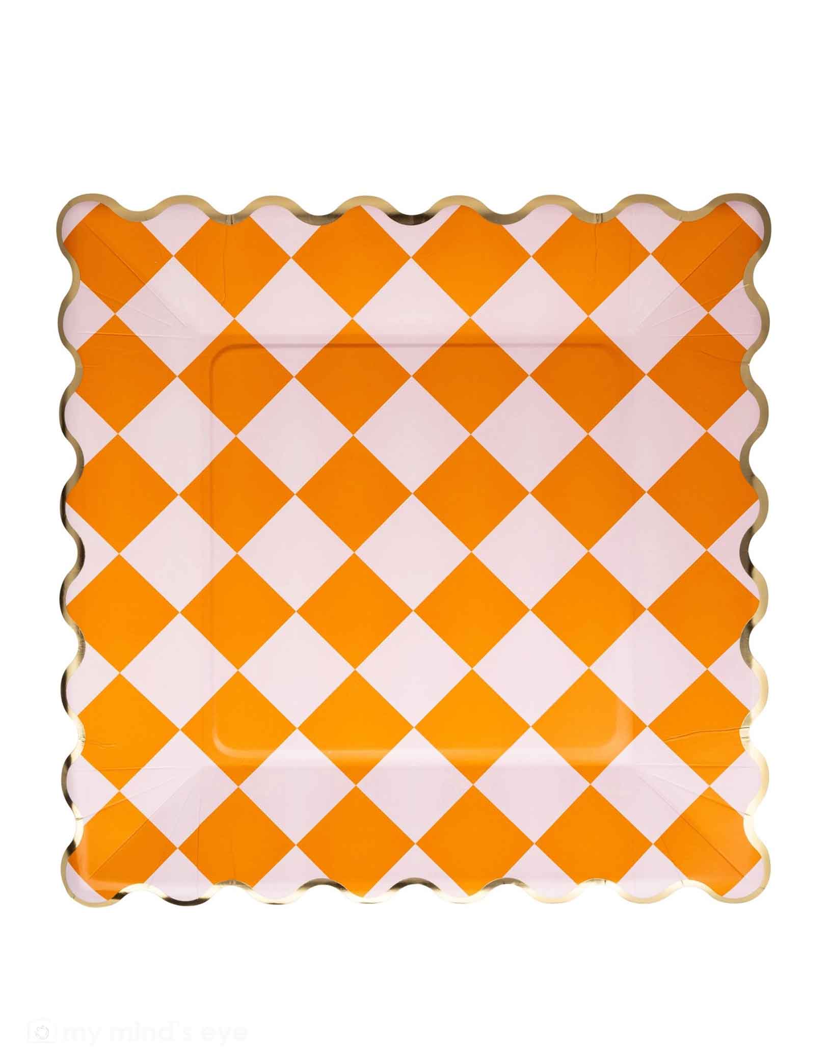 Momo Party's 11" orange and white checkered dinner plate with scalloped edge by My Mind's Eye on a white background. Perfect for serving spooky snacks or festive treats, these eye-catching plates add a playful pop of color to any party table. The bold checkered pattern creates an energetic vibe that'll keep the celebration going all night long!