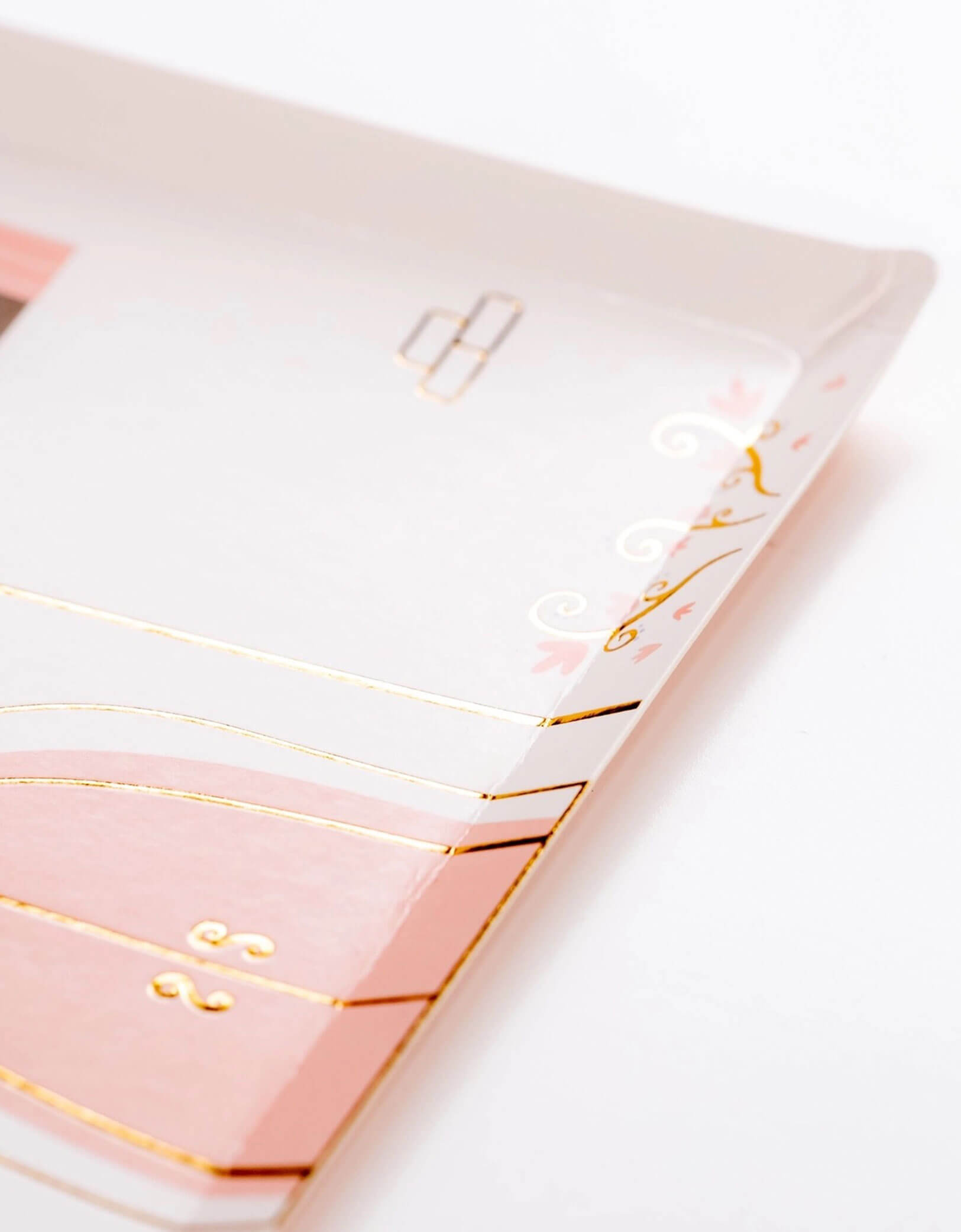A close up of Momo Party's 9.5" castle-shaped princess party plate with pink rooftops and gold foil accents on a white background.