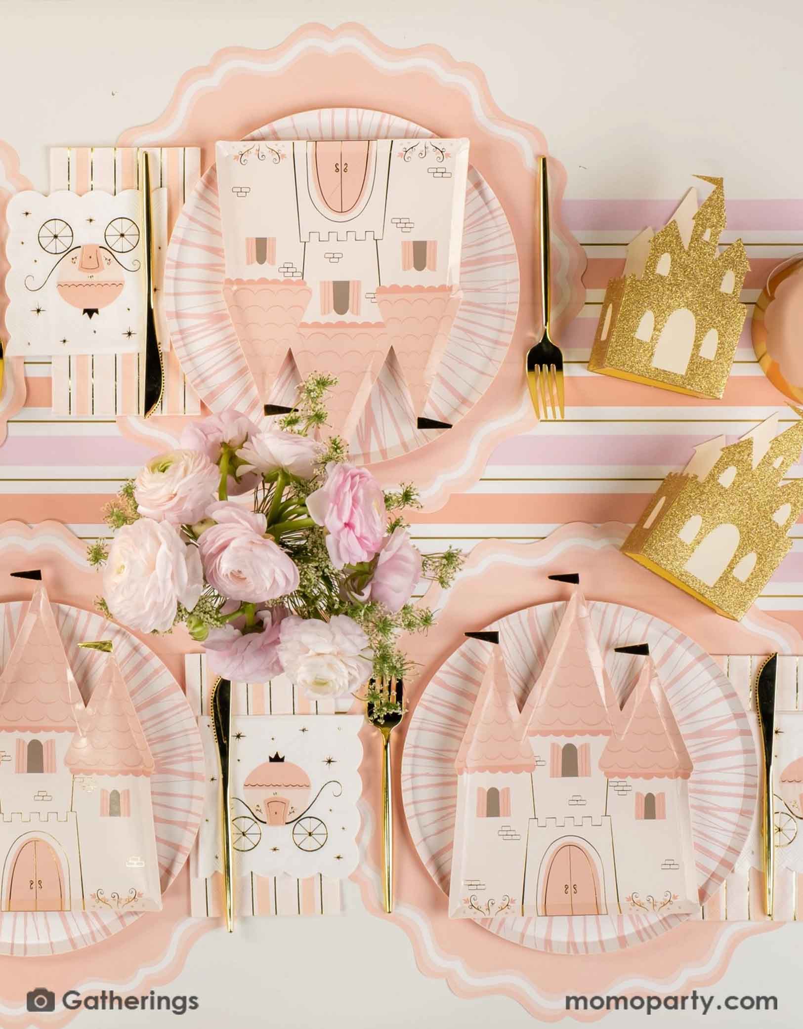 A beautiful princess themed table setting with the castle shaped plates, princess carriage small napkin, gold cutlery, castle shaped treat boxes and the pink and gold striped table runner from Momo Party. With a beautiful floral bouquet on the table, this creates a fairy tale tablescape for a girl's princess themed birthday party.