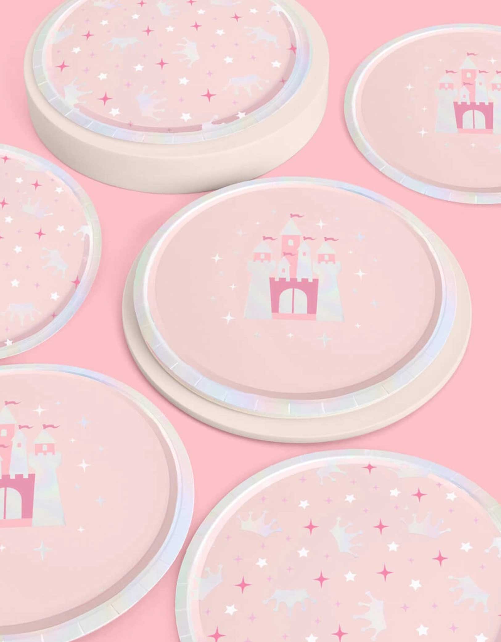 Momo Party's 9" princess iridescent round party plates in two designs each featuring a pink castle design and crowns and star point patterns on a pink background.
