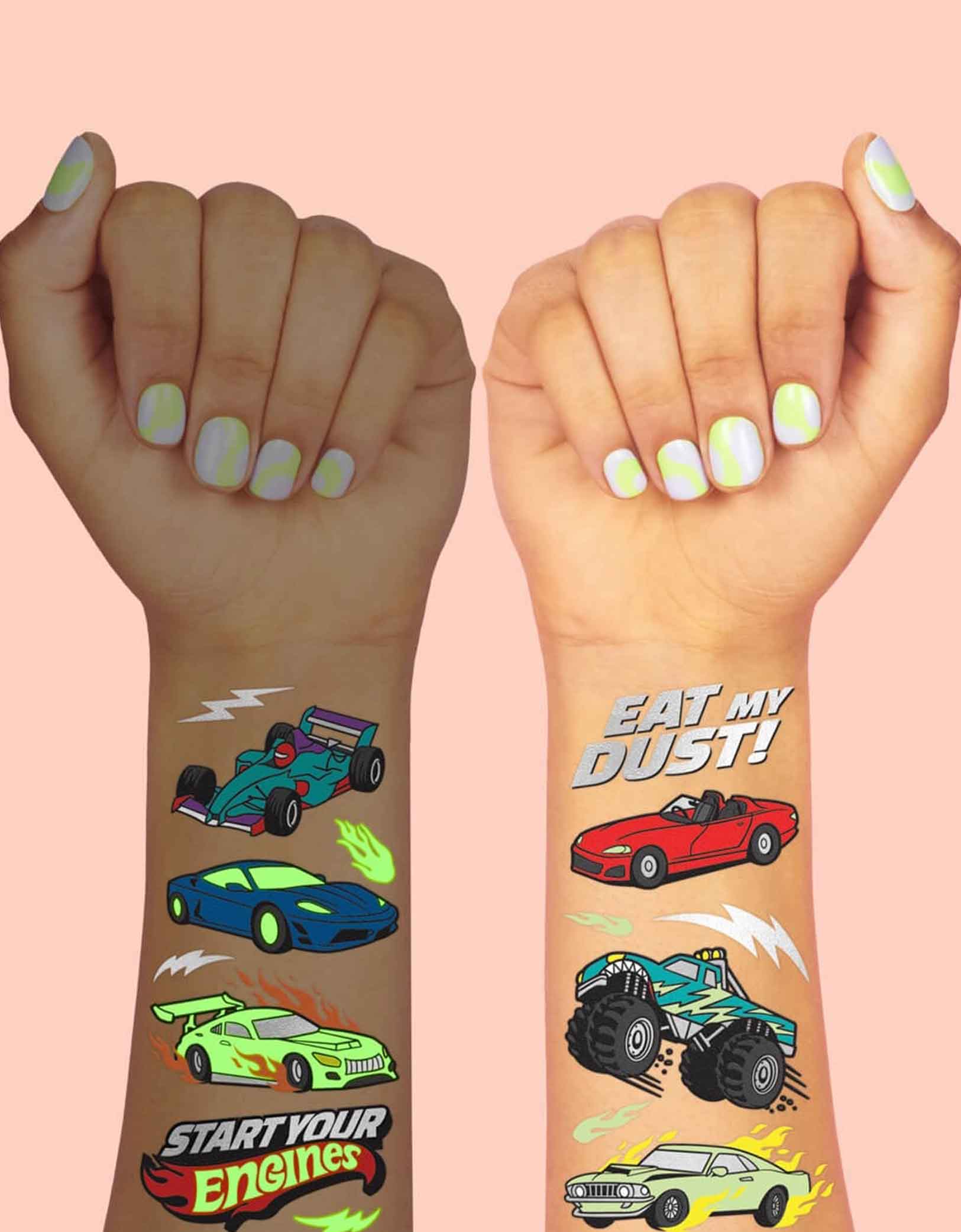 Two hands with colorful race car themed temporary tattoos from Momo Party with text "Eat my dust" & "Start Your Engines". One hand is showing with the glow in the dark effect and the other with regular light on a pink background.