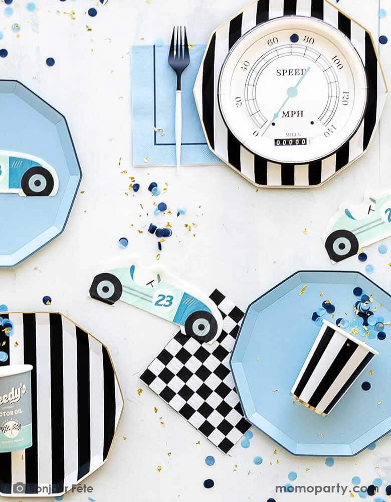 A baby blue, black and white themed race car party table features Momo Party's race car themed and basic themed party supplies including the sky blue dinner plates, the black and white striped dinner plates and party cups, checkered napkins, Miles per Hour speedometer shaped plates, and race car shaped napkins. Along with blue confetti spread around, this makes a modern yet playful tablescape for boy's car themed birthday celebration.
