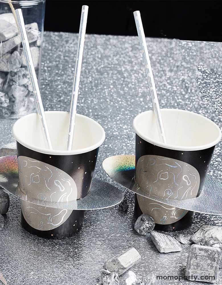 A party table dressed in silver foil tablecover with some space rock decorations on the table, along with two of Momo Party's 9" planet party cups by Hooty Ballloo topped with silver foil straws, makes this a great decorating idea for kid's space themed party, be it a "Two the Moon" 2nd birthday party or a "First Trip around the Sun" first birthday party.