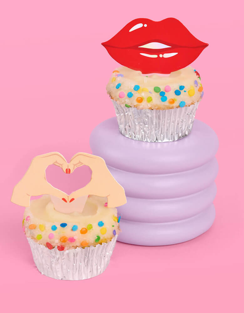 Three birthday cupcakes adorned with Momo Party's Era's Party Cupcake Toppers by Xo, Fetti. Comes in a set of 24, these Taylor Swift-themed dessert/cupcake toppers are with iconic designs including butterflies, red lips, disco balls, cassettes, guitar picks and heart hand symbols. They're perfect for to celebrate your Swiftie girl's special birthday.