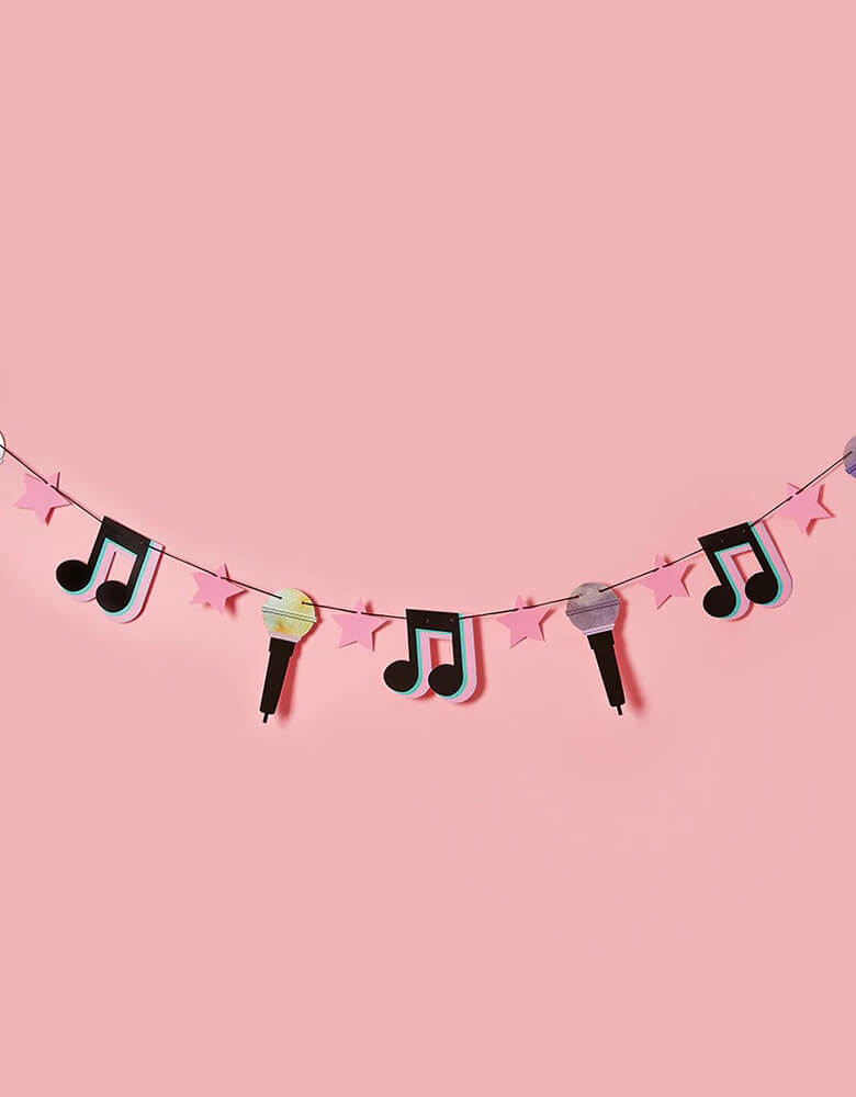 Momo Party's 6.5 ft let's day party banner featuring musical notes, microphone, pink star pennants by Hooty Balloo, with a pink background. This banner is perfect for a teenagers and preteens' dance party, Taylor Swift themed, or TikTok inspired party.
