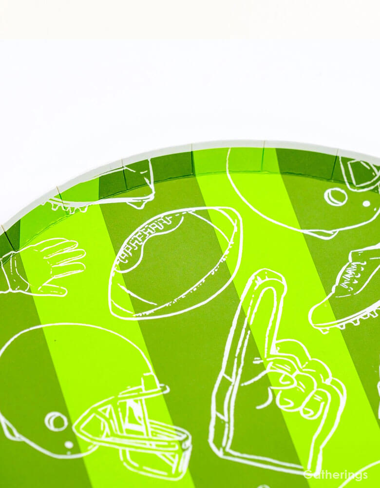 A close up shot of Momo Party's 8.5" Touchdown Dessert Plates by Gatherings. Elevate your game day celebration with these touchdown plates! These sturdy and stylish plates are the perfect addition to your football-themed party. With a unique design and high-quality materials, you and your guests can enjoy your favorite treats with ease. Score a touchdown with these plates and make your party a winner!