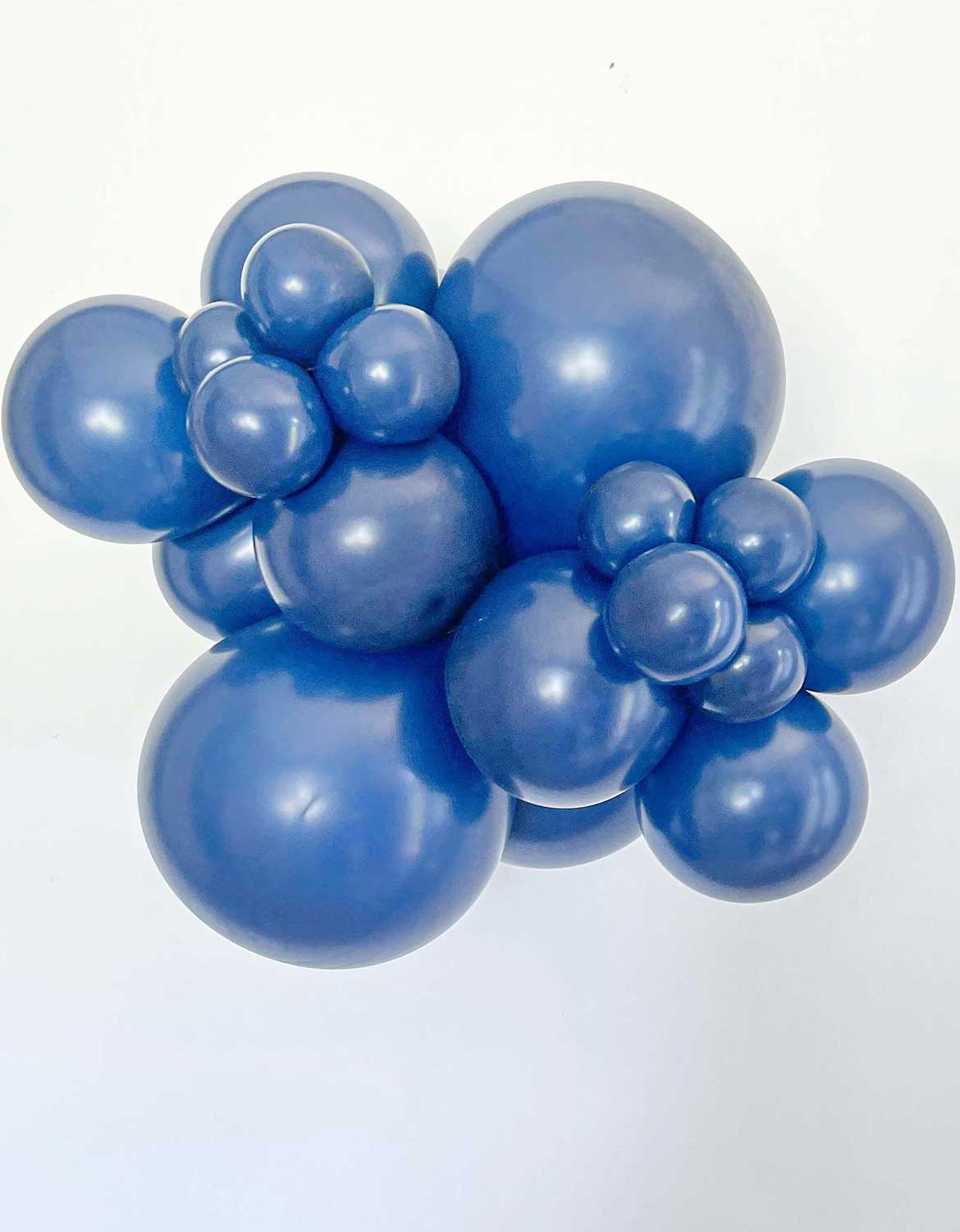 A cluster of Tuftex Navy latex balloons in various sizes, arranged in a decorative cluster against a plain white background.