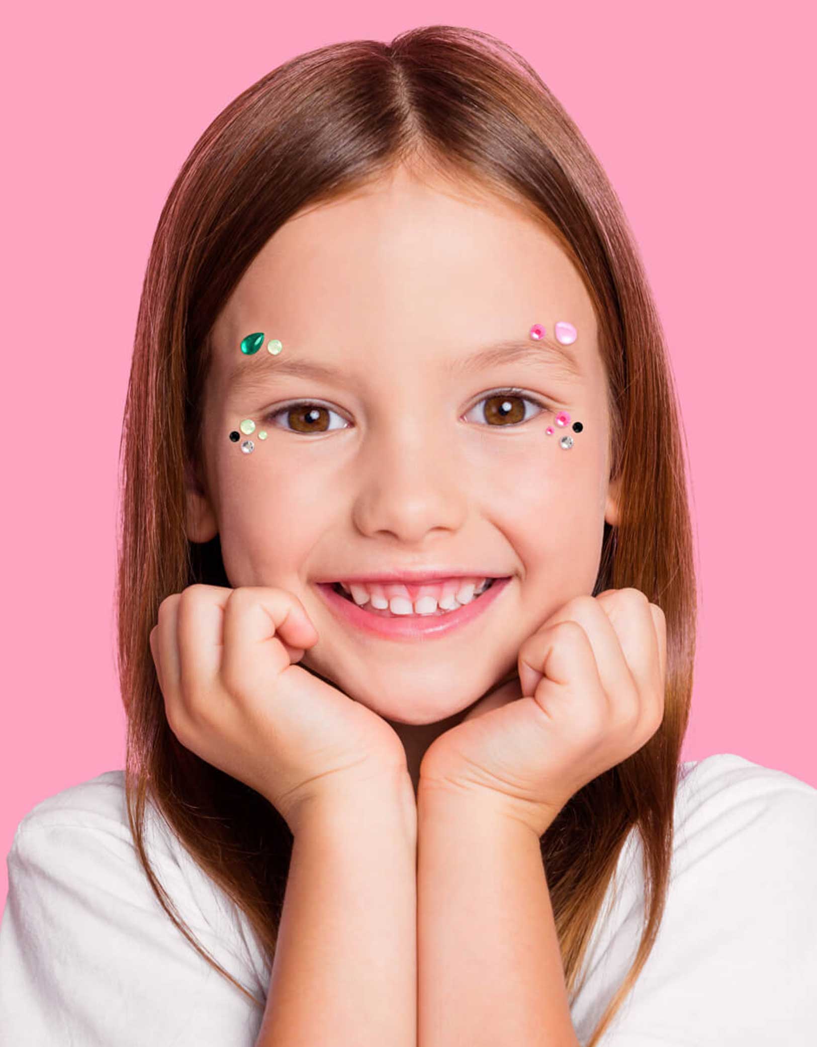 A young girl with Momo Party's Wicked themed gem stickers on her face against a pink background. Perfect for girl's Wicked themed birthday party, witch themed Halloween bash or a magical gathering.