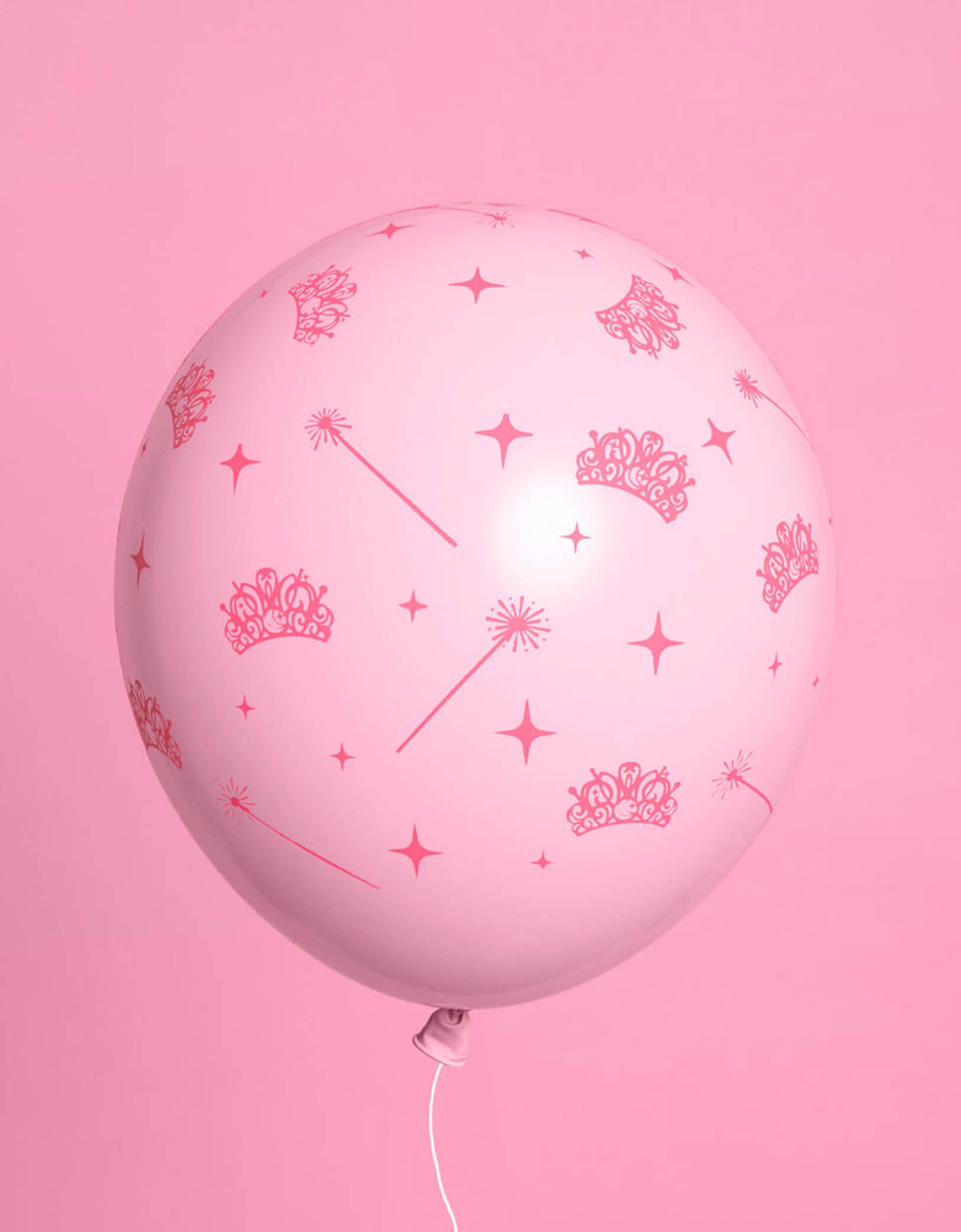 A pink Wicked themed latex balloon with witch themed patterns including pink tiaras, wands, and star points on a pink background.