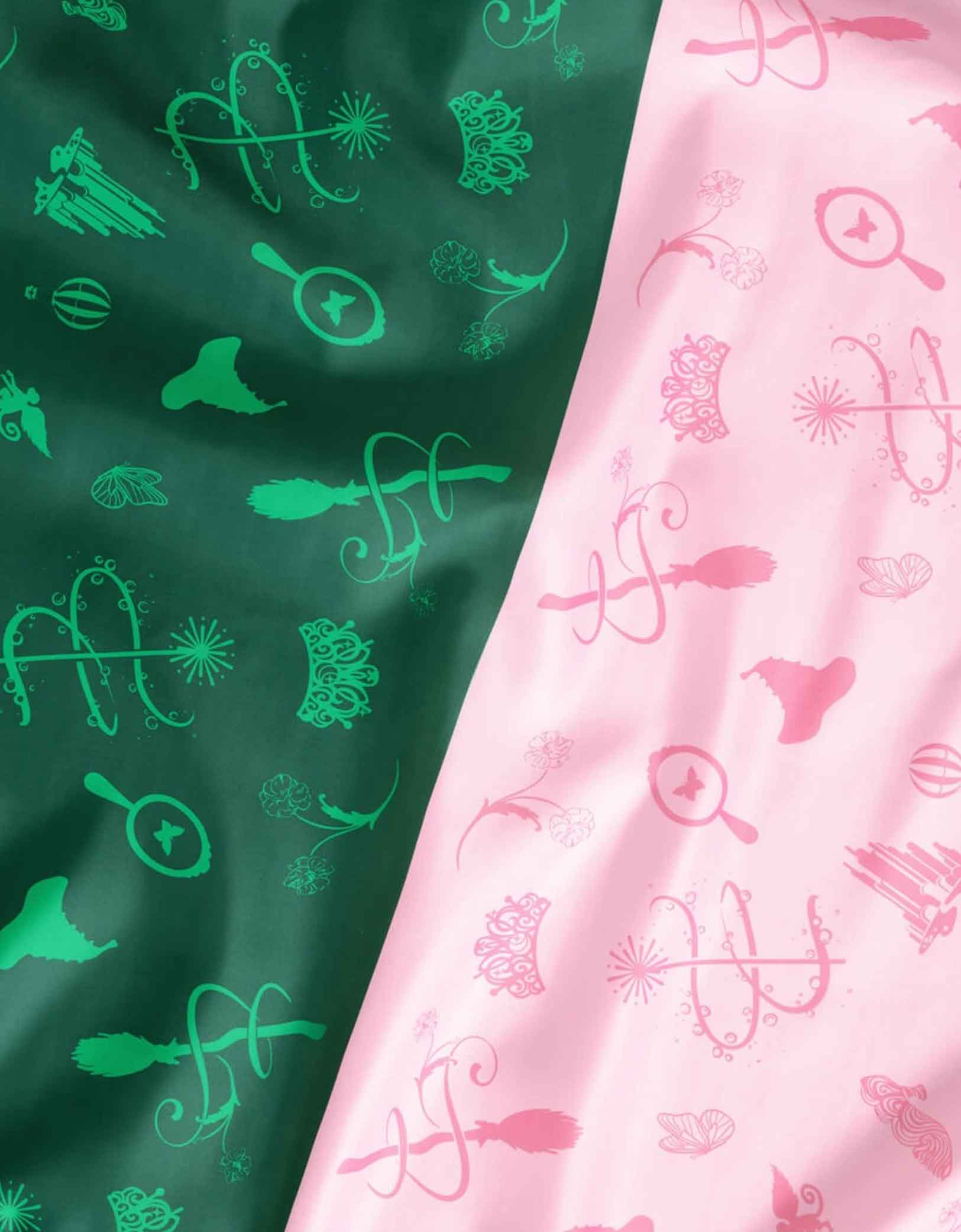 A close up of Momo Party's two patterned Wicked party tablecloth, one green with Wicked themed patterns and the other pink.