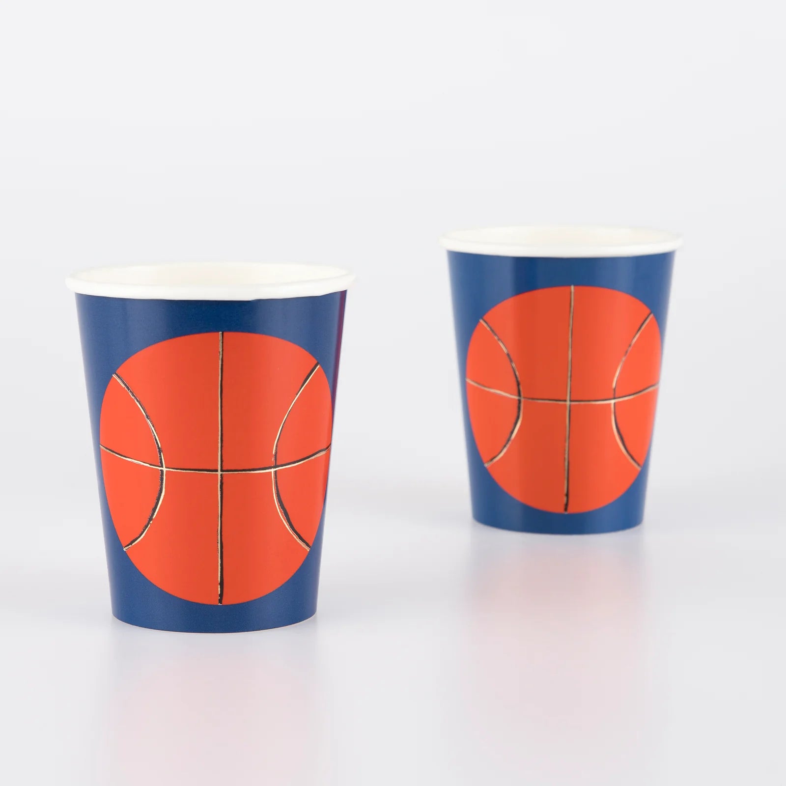 Momo Party's 9oz basketball party cups by Meri Meri, comes in a set of 8 party cups in navy blue with basketball illustration on them, they're perfect for kids and adults' birthday parties, post match parties or for a get-together when you're cheering on your favorite team. Ideal for drinks or fill with popcorn or sweet treats.