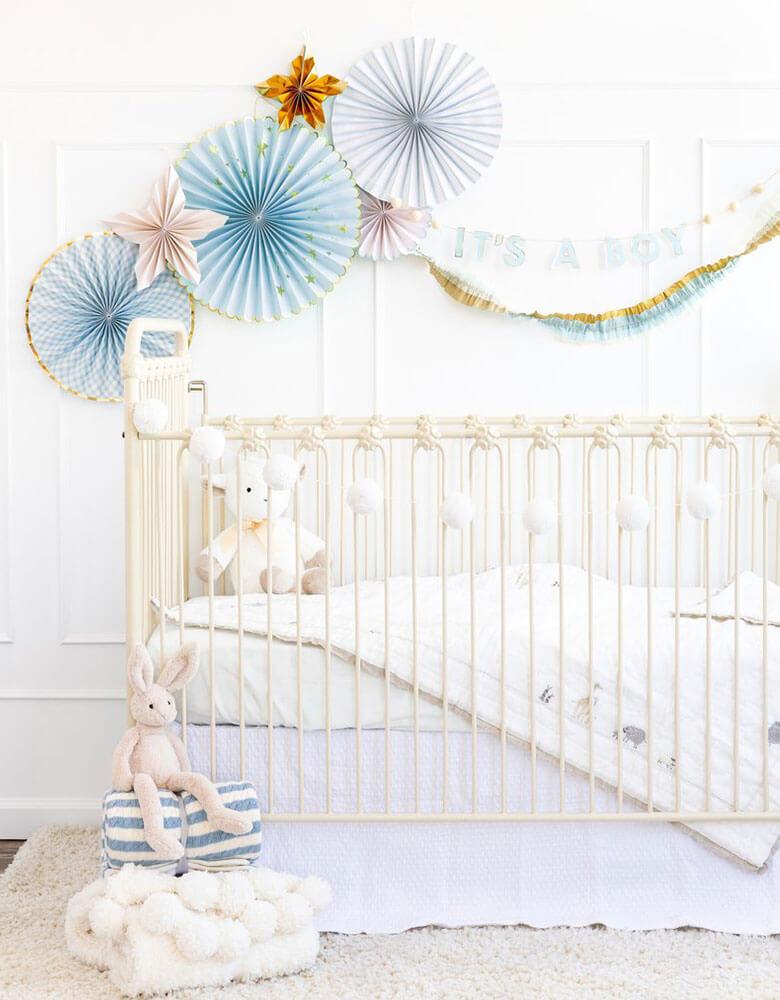 Baby boy's nursery decoration ideas featuring my mind's eye baby blue paper fans and "it's a boy" banner on the wall