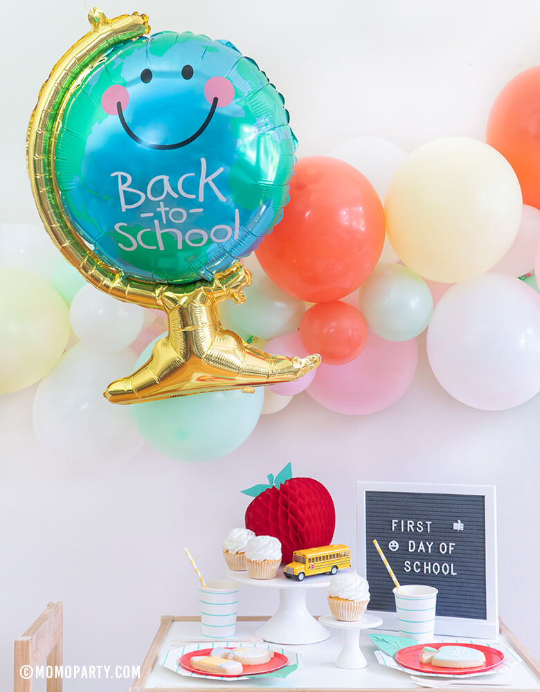 Momo party - Morden Back To School Party inspiration with Anagram Back To School Globe Foil Mylar Balloon, 6ft long Balloon Garland Assorted in Pastel Yellow, Pink, Mint, Carol, White Latex Balloon for Backdrop decoration, Letter board with "First Day of School" sign, Oh happy day Cherry Red side plate, Aqua Striped Large Plates and cups, Leaf Napkins as tableware, Honeycomb Apple, cupcakes, and school bus toy on cake stand