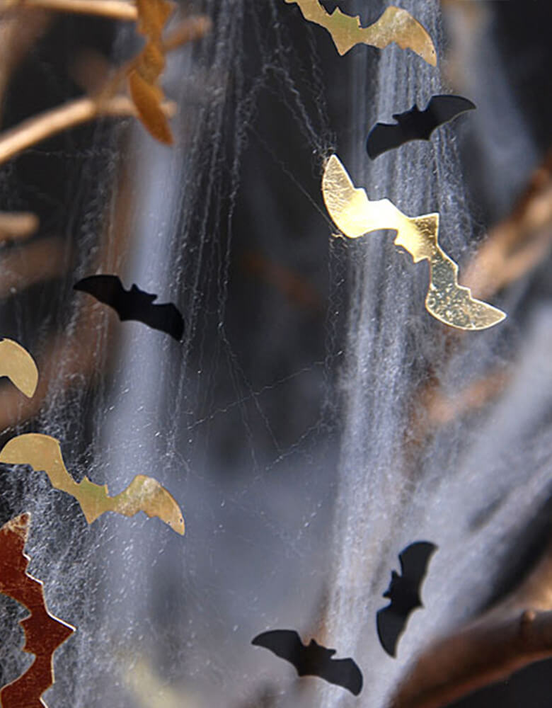 Party Deco Bats Confetti, in a shape of bat in black and gold on halloween spider web decoration for halloween party. also Add some fun to your Halloween party by spreading this set of bats confetti to your halloween table