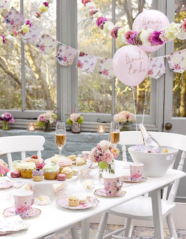 A beautiful bridal shower set up with Talking Tables Talking Tables Blossom Girls Party Supplies including cups, plates floral garlands and pink latex balloons